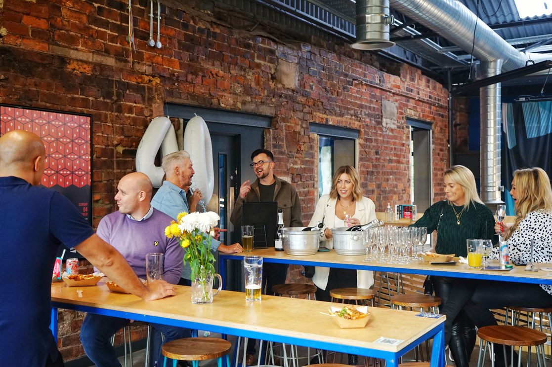 Networking event at North Brewing Co with attendees around a long table.