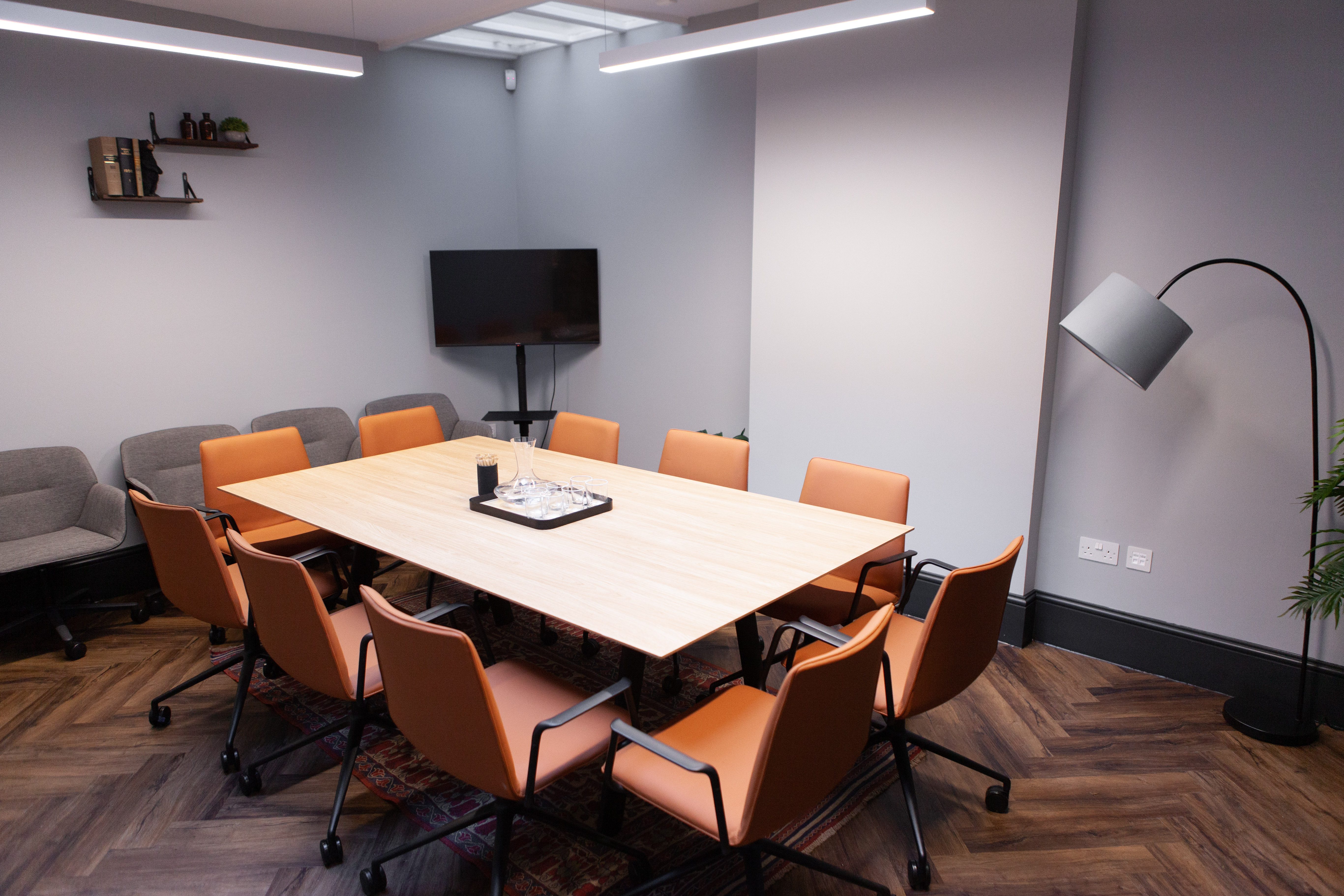 Modern meeting room with wooden table, ergonomic chairs for collaborative events.