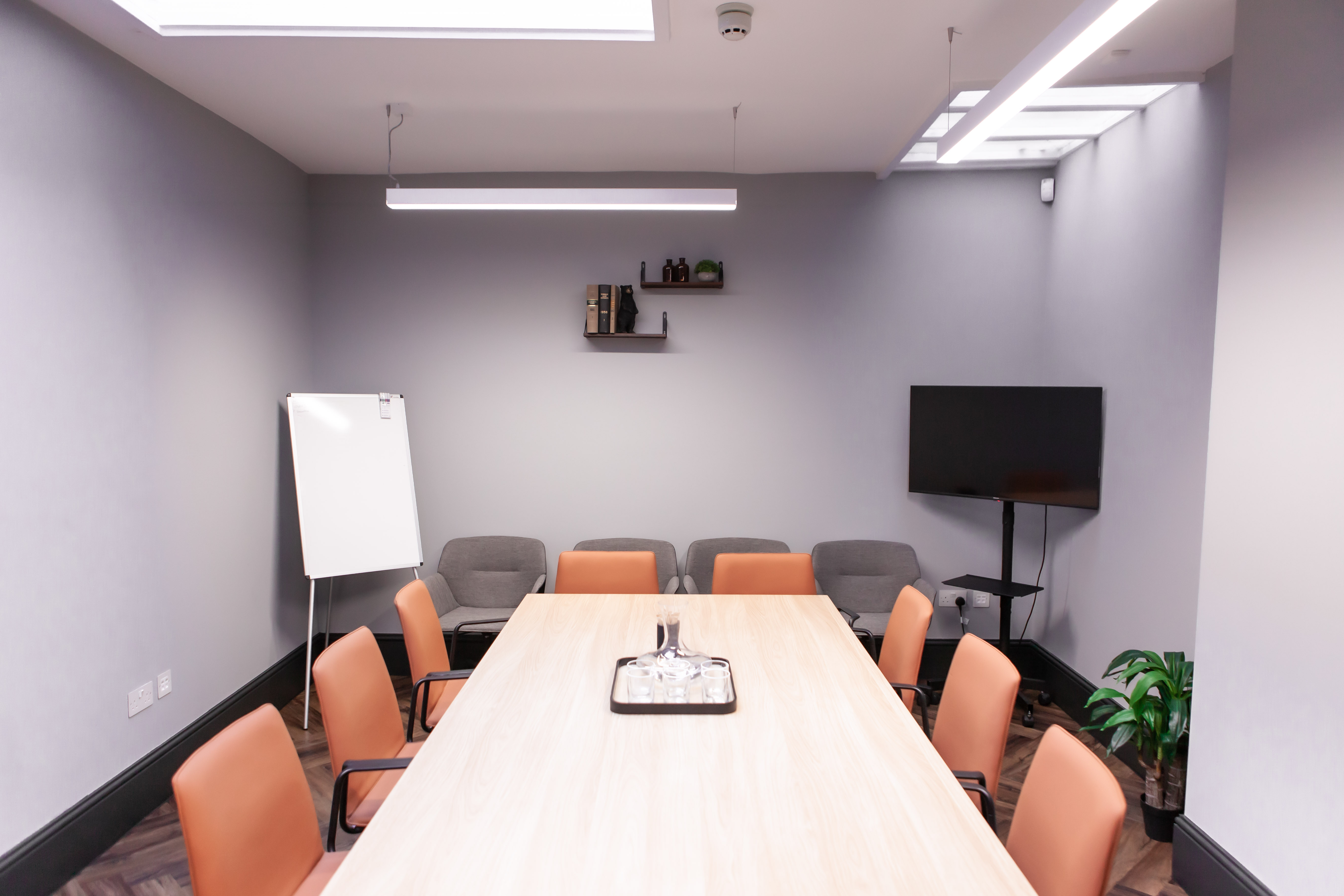 Modern meeting room with wooden table, ideal for workshops and presentations.