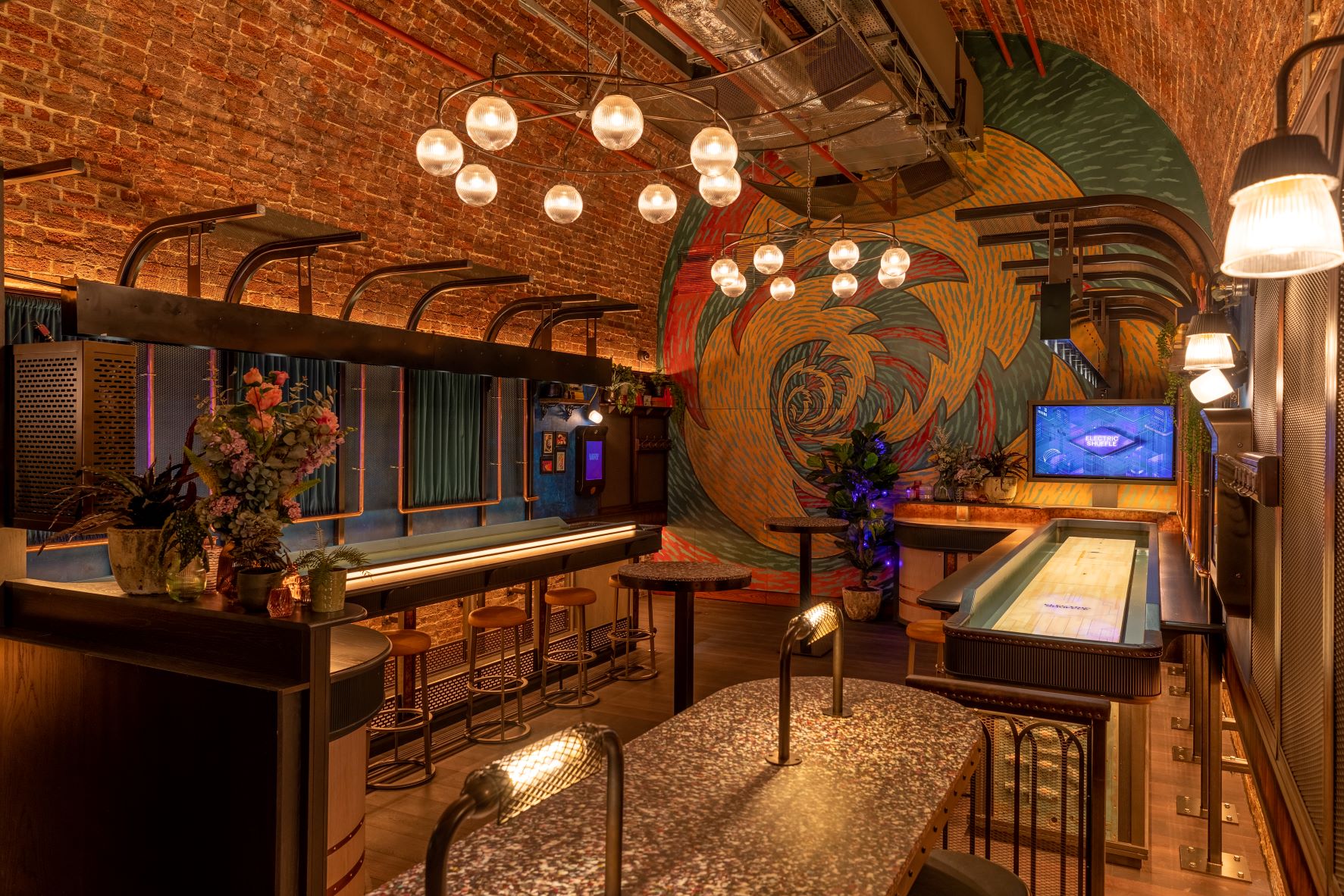 Stylish event space at The Widdowson, featuring rustic brick walls and shuffleboard.