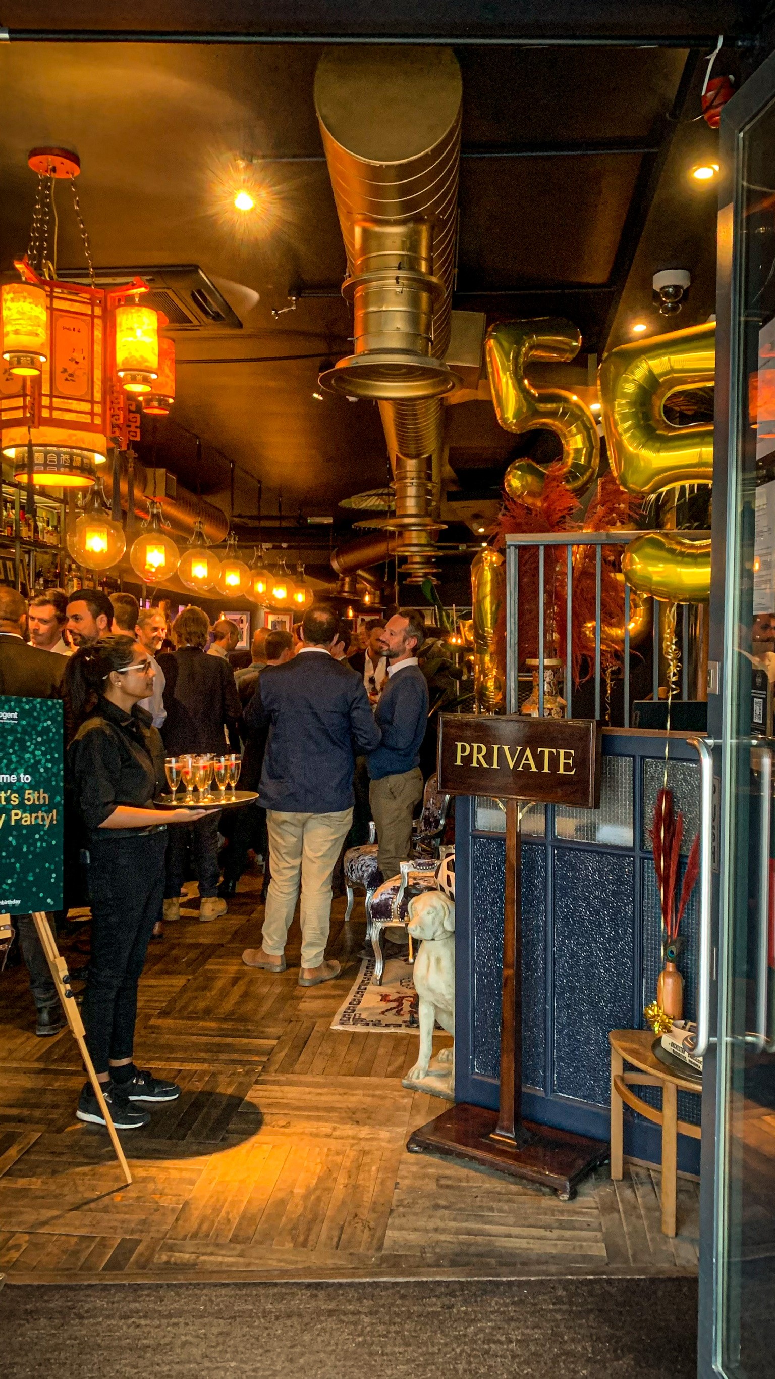 Vibrant private event at The Last Talisman venue with warm lighting and festive decor.