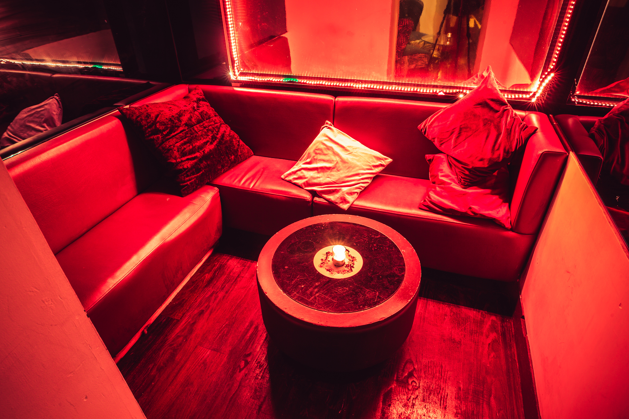 Cozy lounge with plush red seating for VIP receptions and networking events.