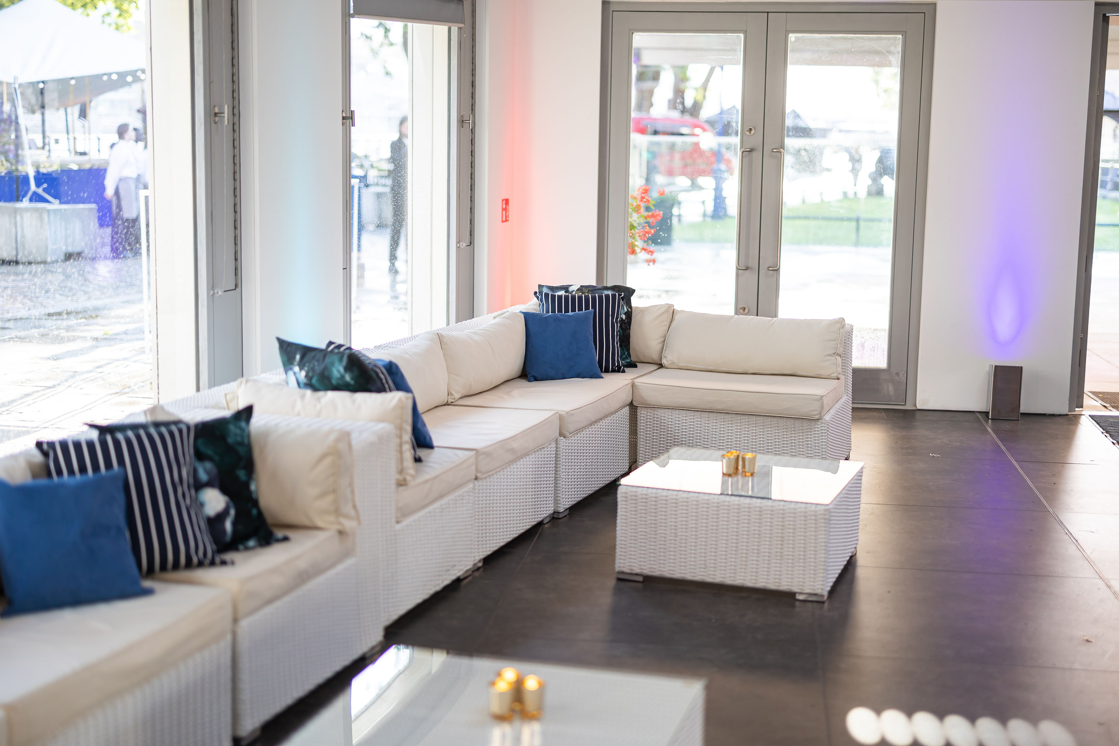 Stylish lounge area with white sectional sofa at The Reveller, Tower of London events.