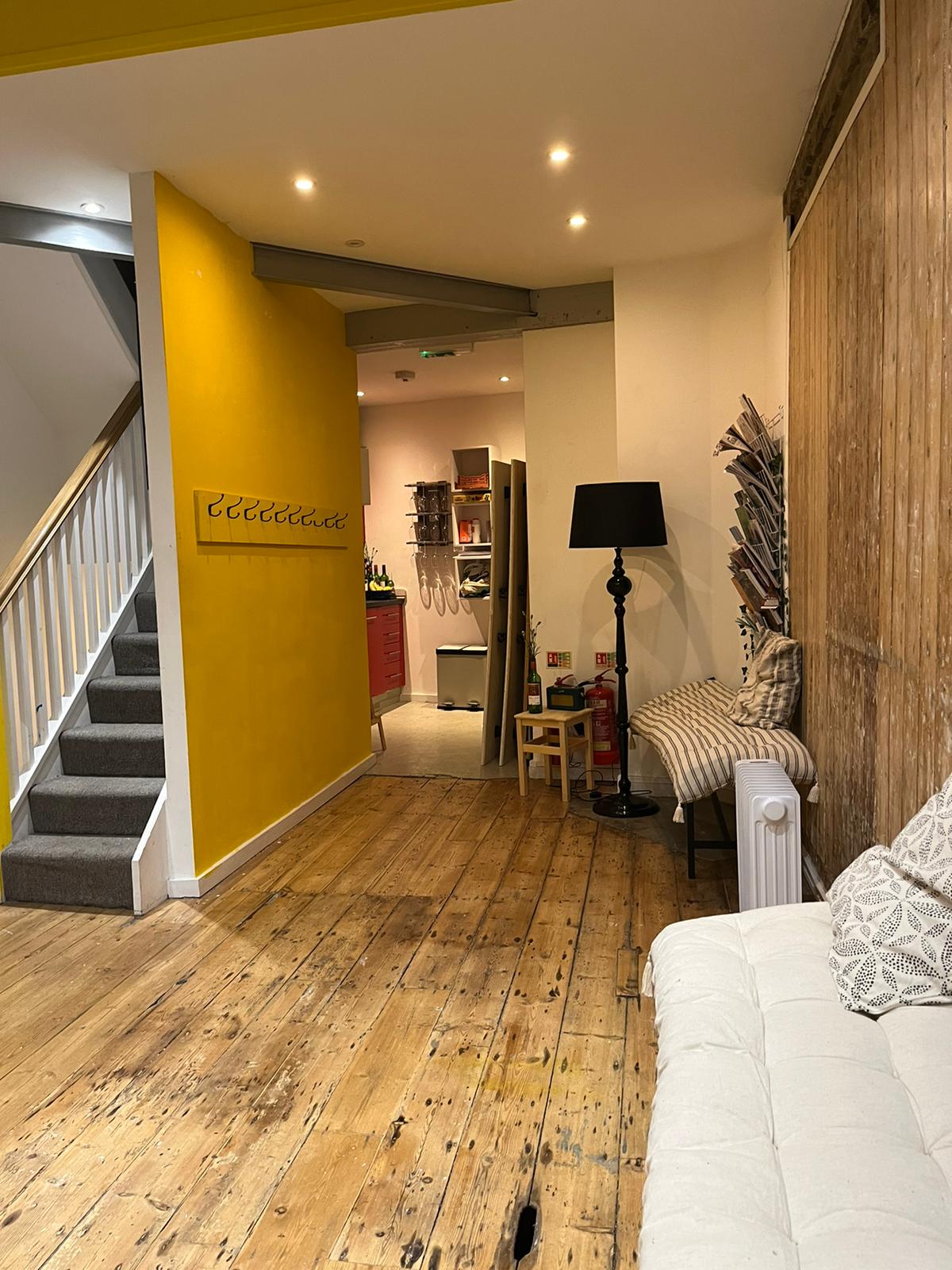 Cozy pop-up space with bright yellow wall for informal meetings and small events.