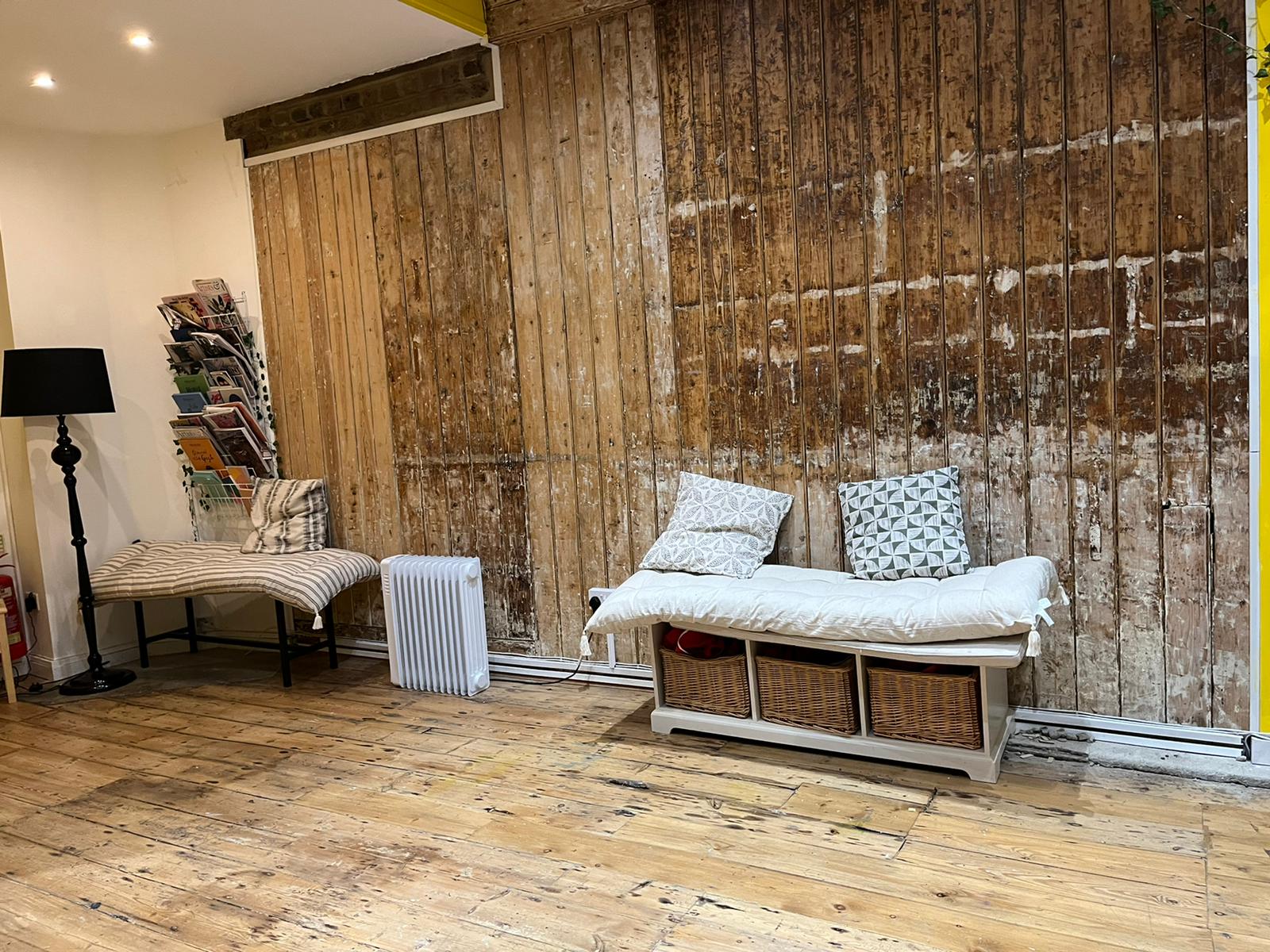 Cozy rustic pop-up meeting space with wooden wall, perfect for creative workshops.