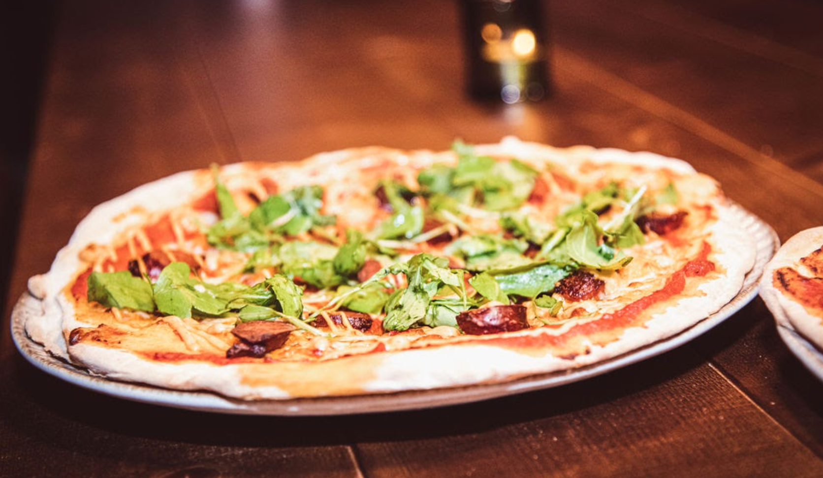 "Vibrant pizza with fresh greens in Royal box at Vagabond Victoria for events."