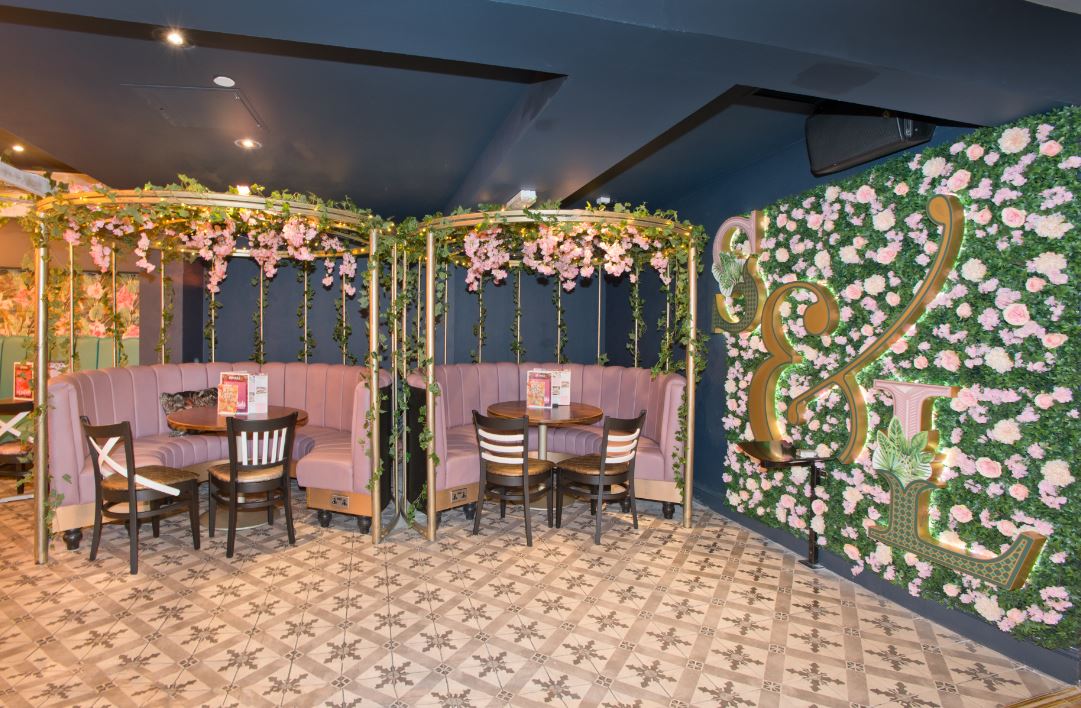 Stylish meeting space with floral decor at Slug & Lettuce, ideal for gatherings and events.