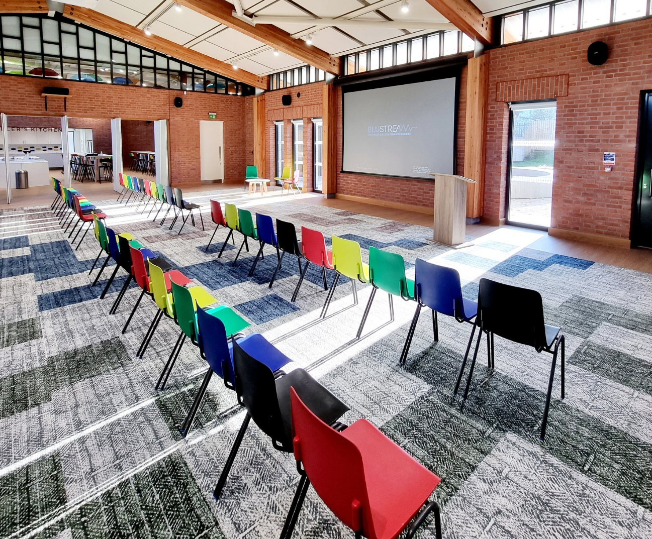 Ollerenshaw Room: bright meeting space with colorful chairs for workshops and presentations.
