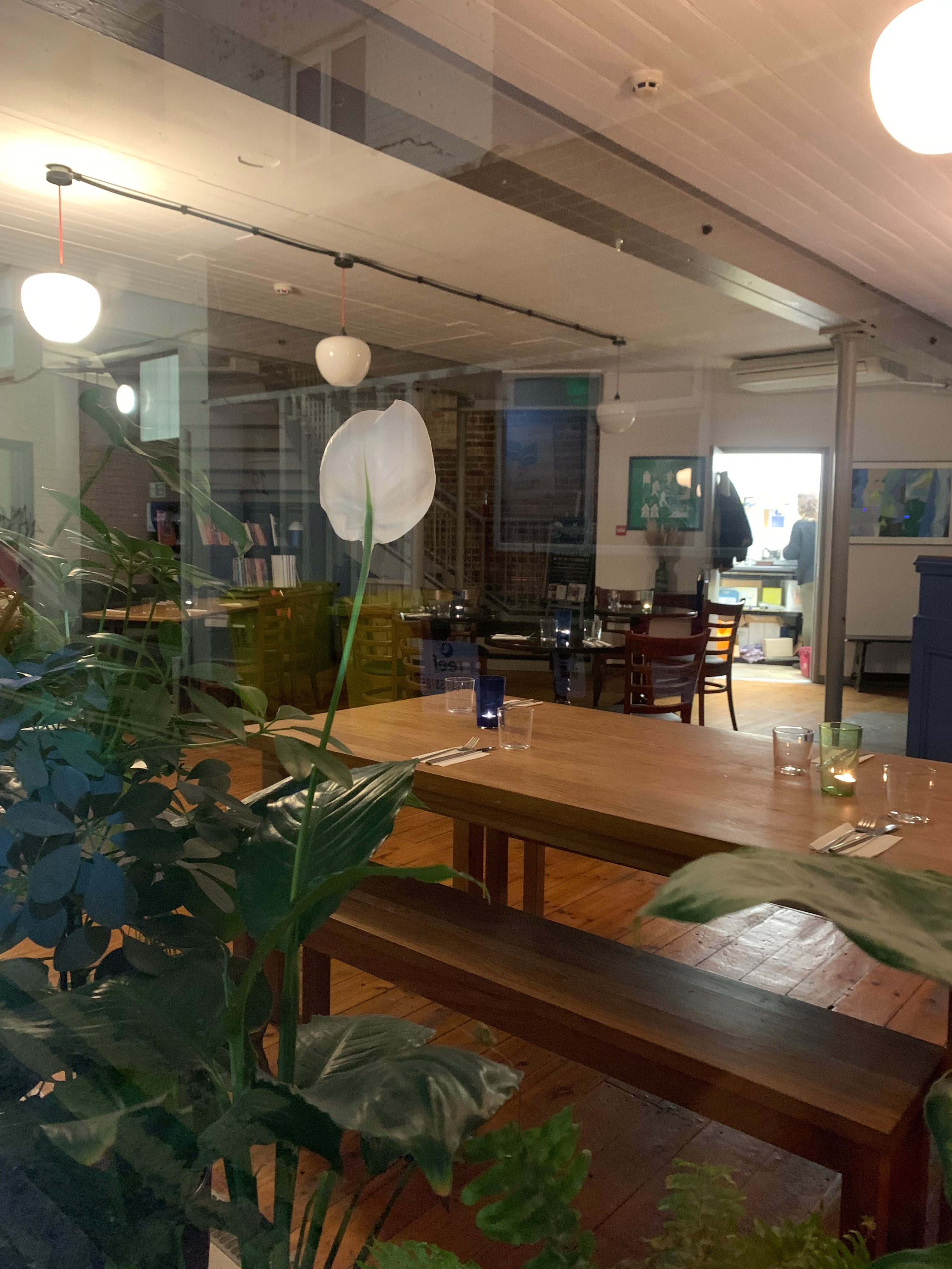 Cozy event space at Bodega Eastbourne with wooden tables, ideal for gatherings and meetings.