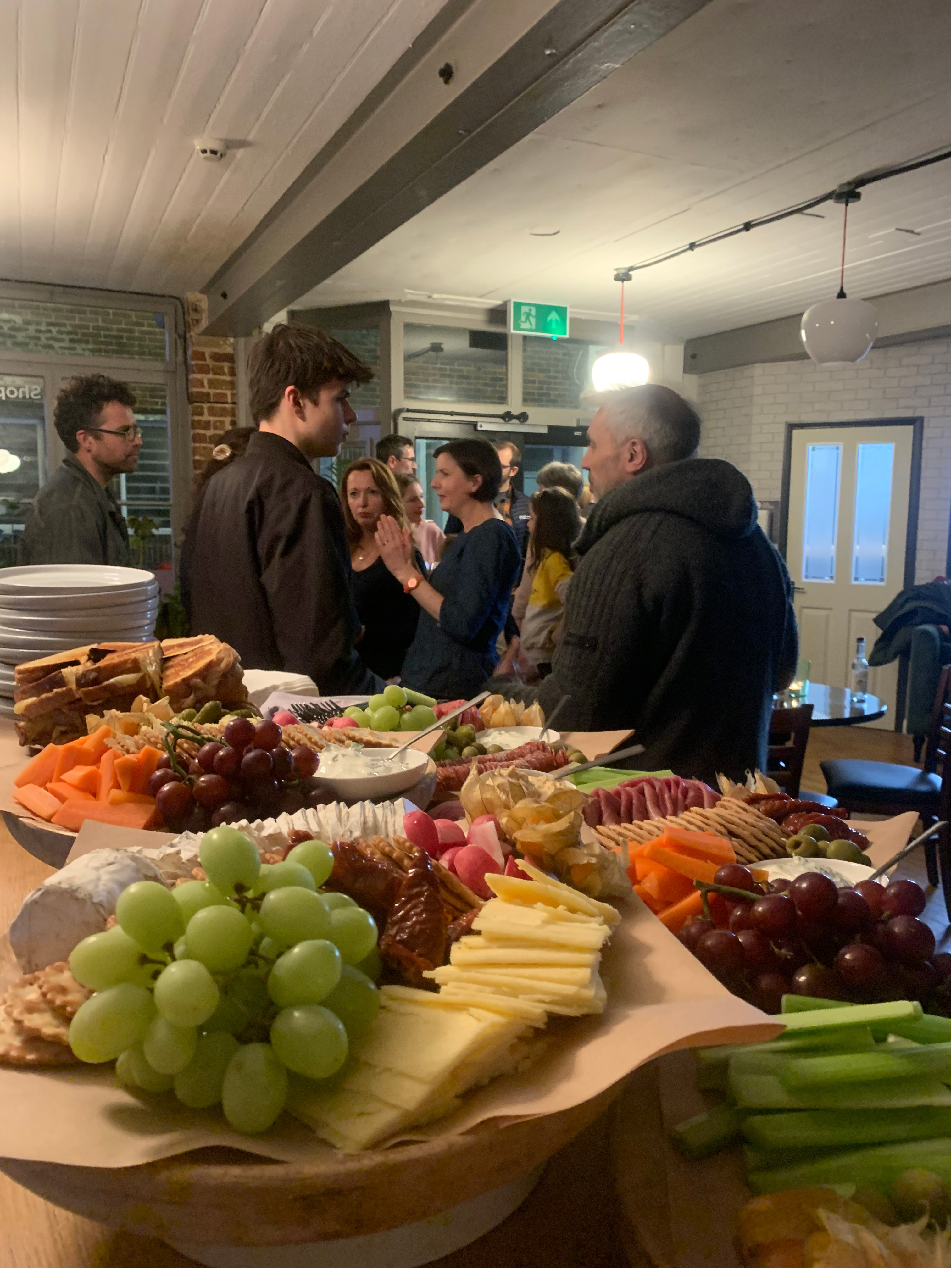 Vibrant networking event at Bodega Eastbourne with food platters and casual decor.