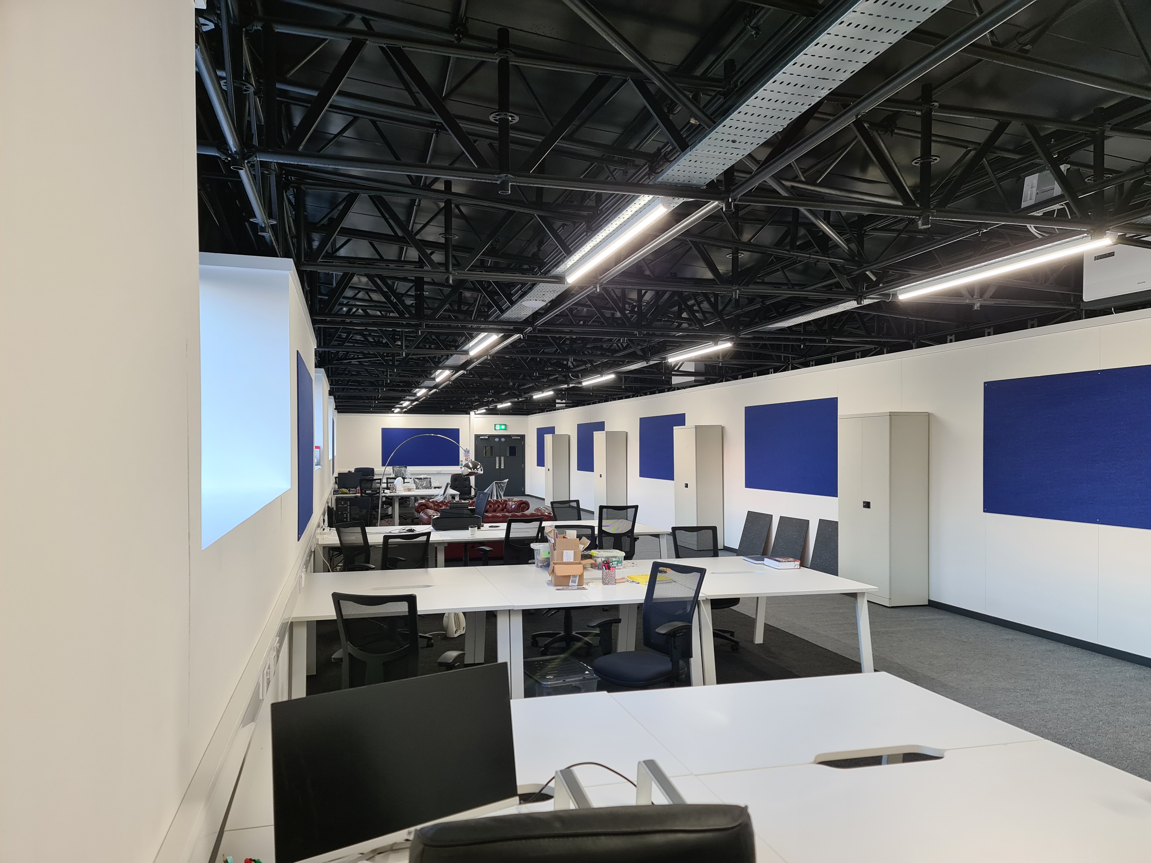 Modern meeting space with blue accents, perfect for workshops and team meetings.