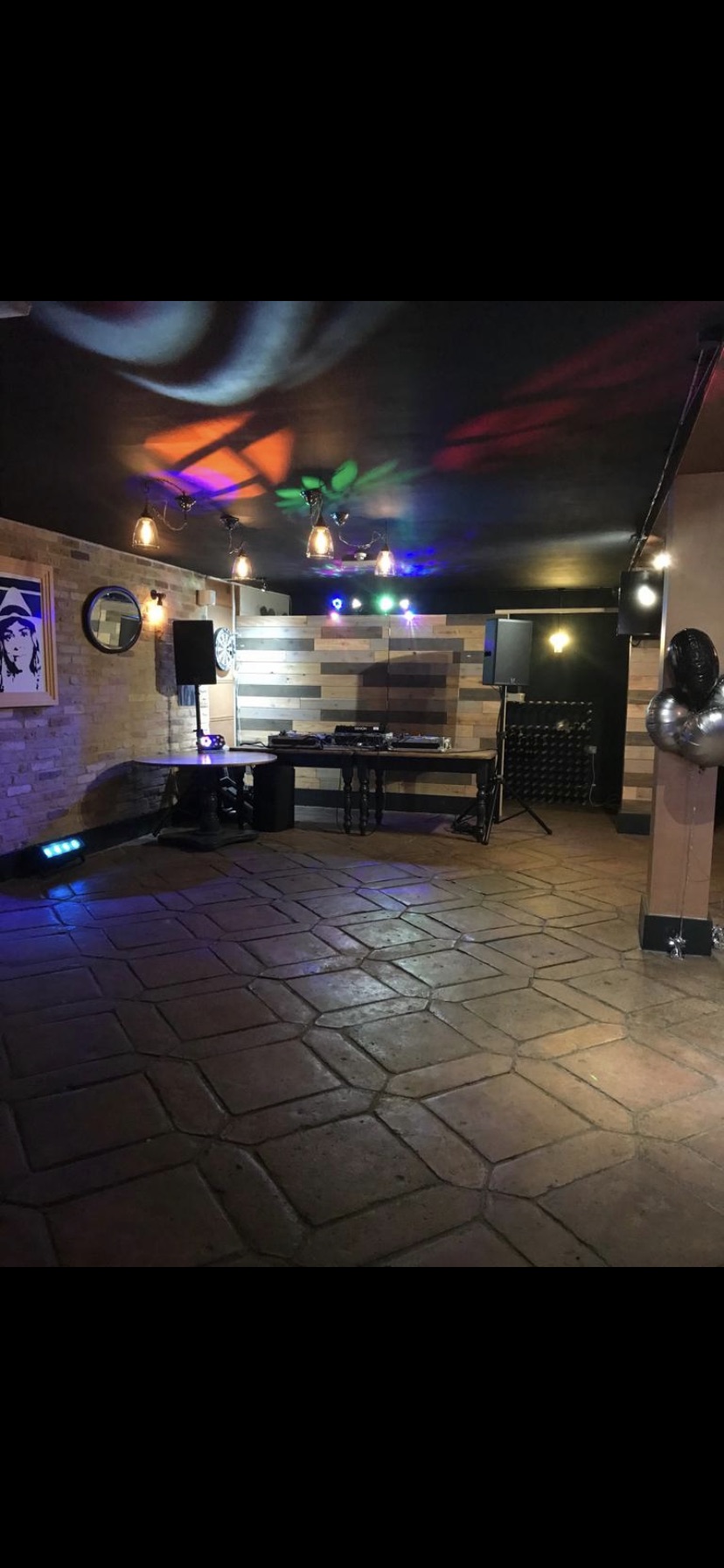 Versatile event space with DJ setup and ambient lighting for parties and networking.