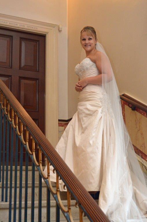 Bride at staircase in elegant dining room, perfect for wedding photography and events.