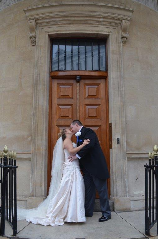 Couple kissing in elegant dining room, perfect for weddings and special events.