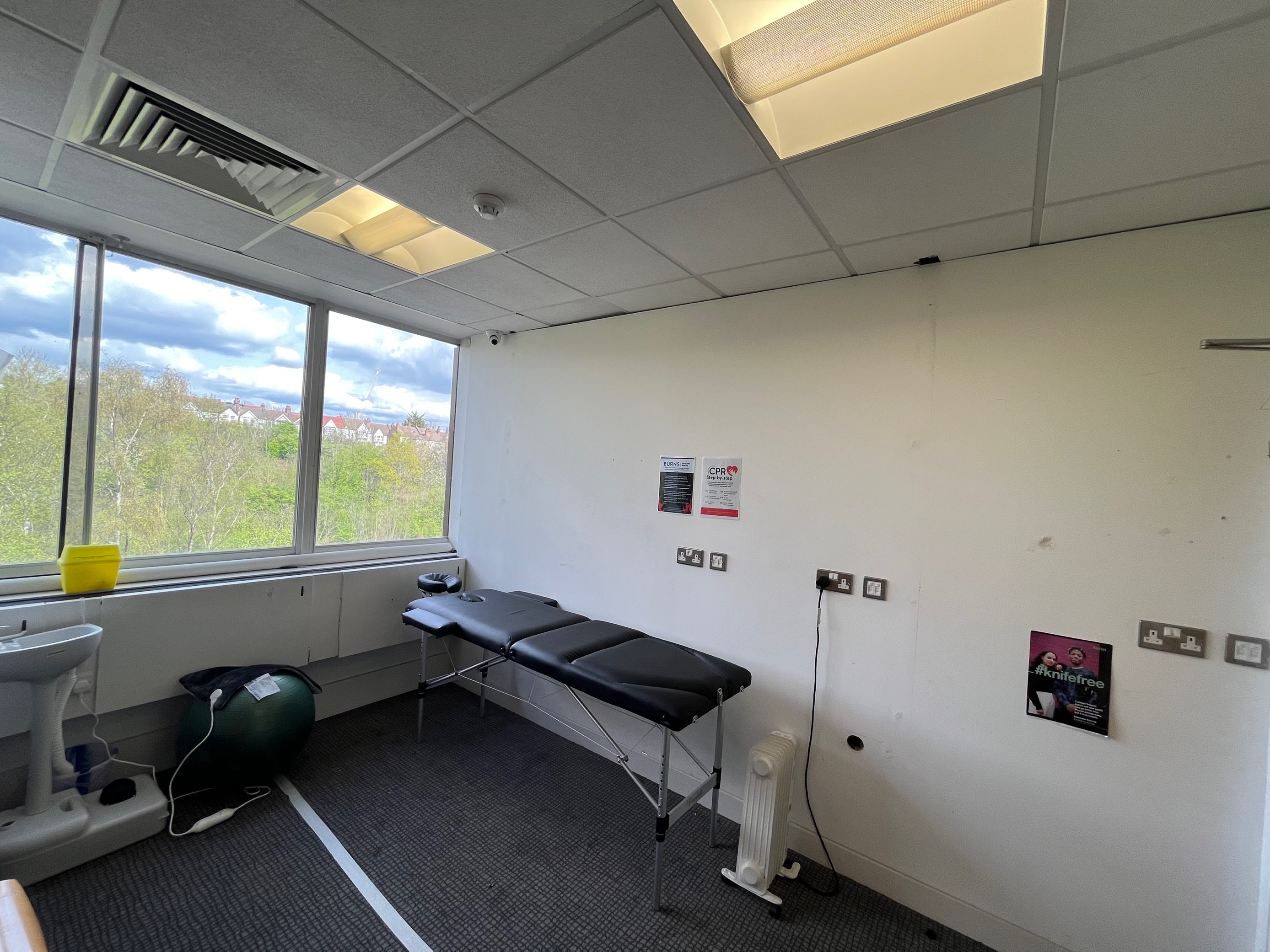 Minimalistic London meeting space with treatment table for wellness events.