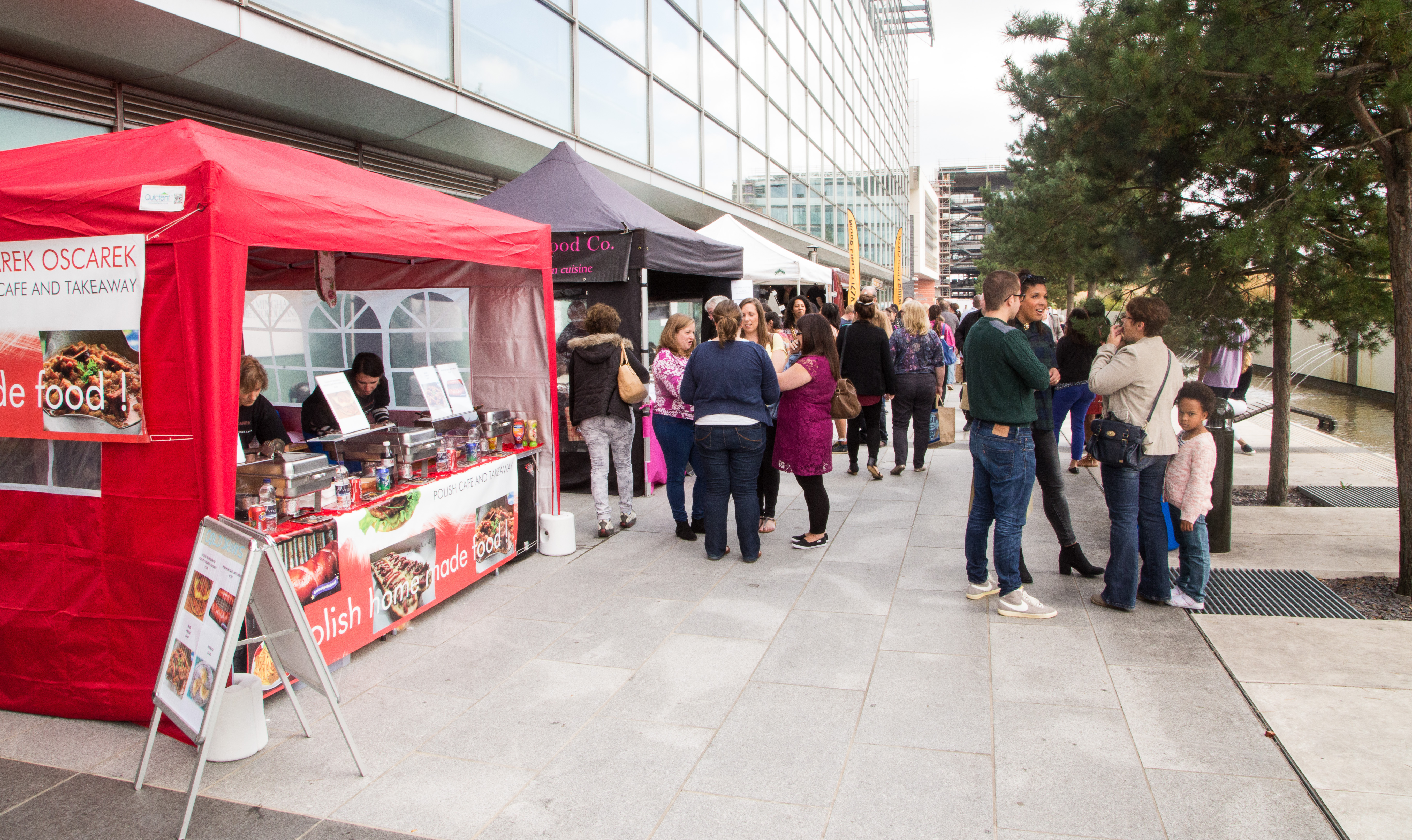 Vibrant outdoor event at Millennium Point with food stalls and community engagement.