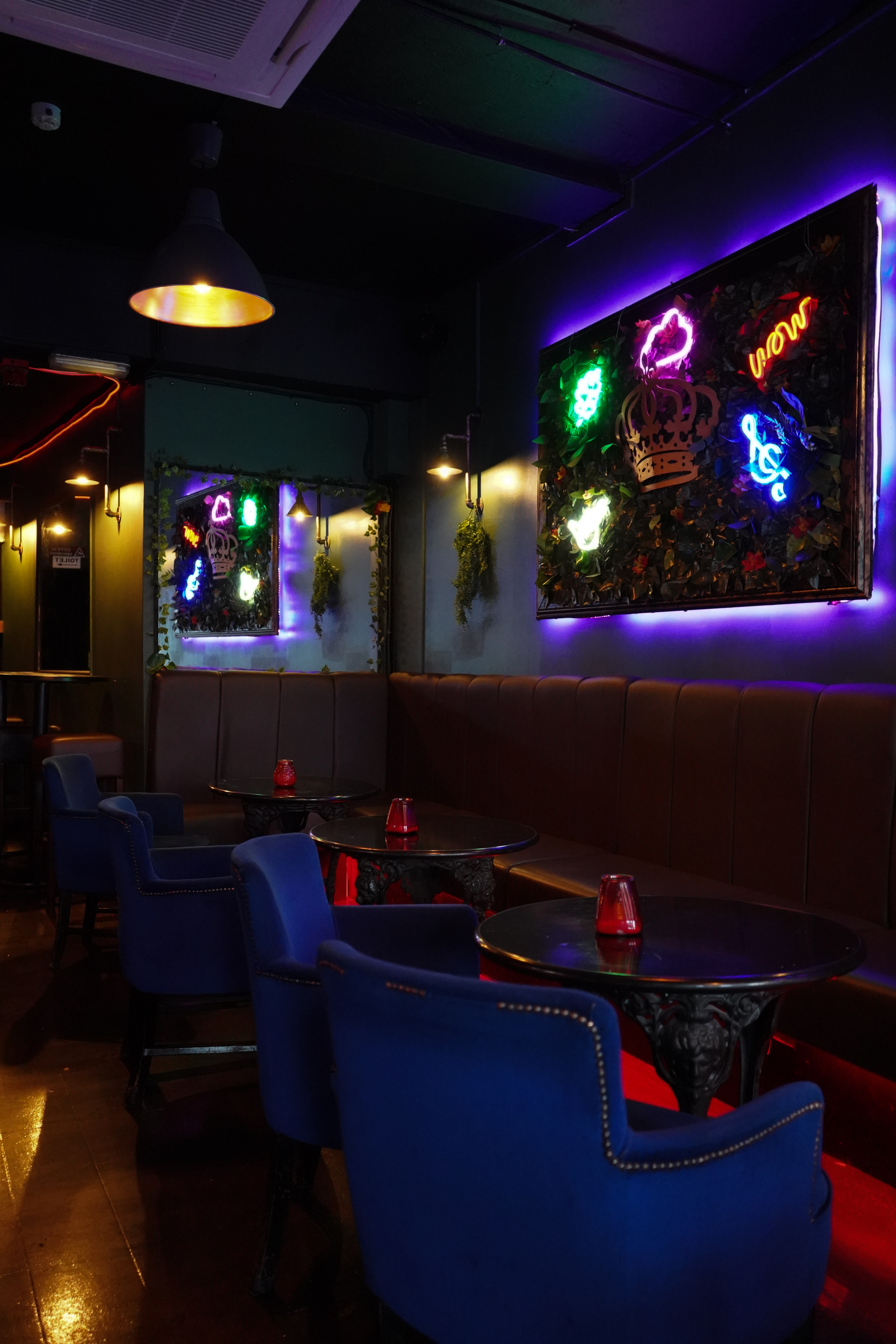 Stylish event space with plush seating and neon decor for gatherings and networking.