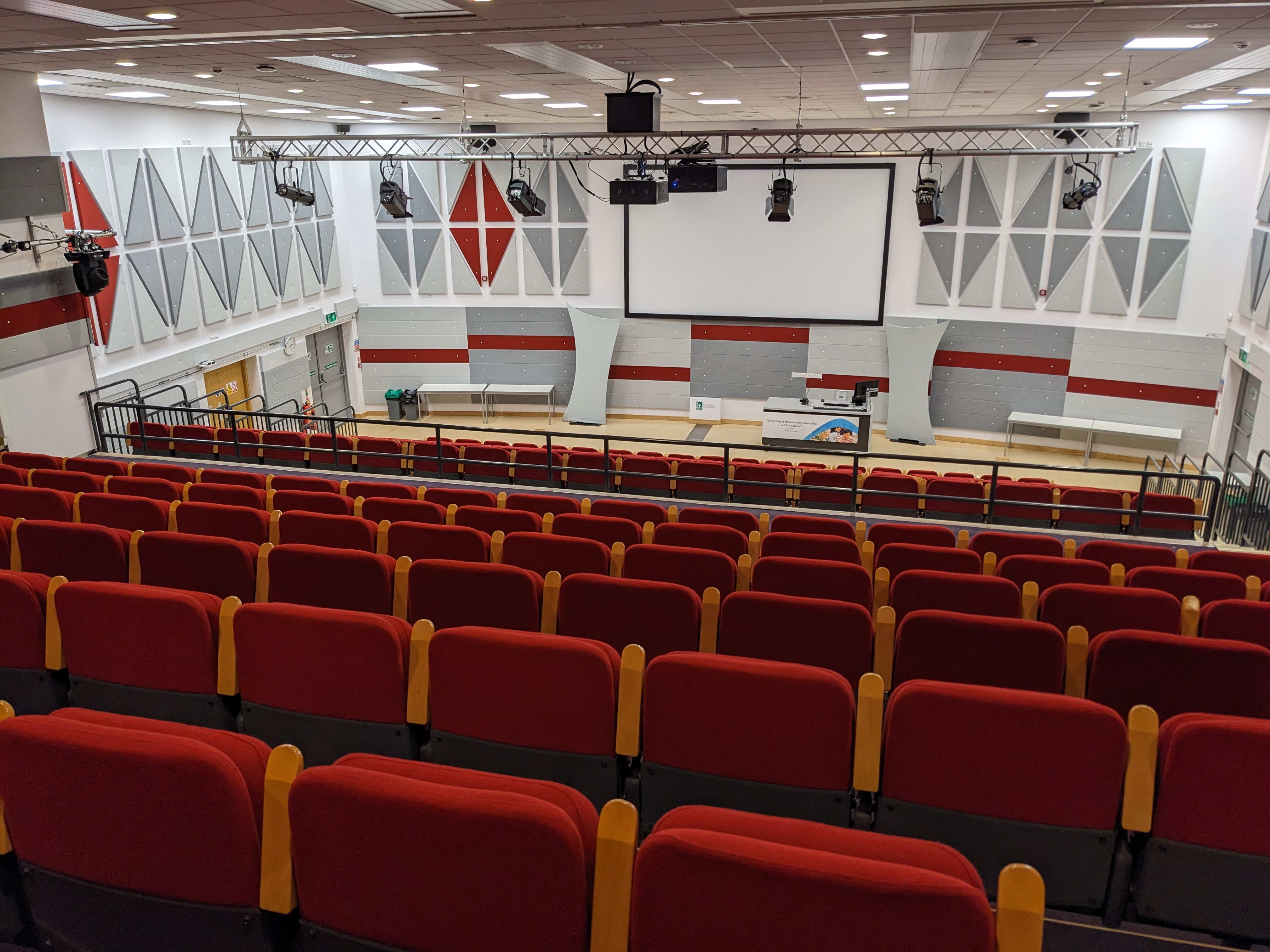Lecture theatre with tiered red seating, perfect for conferences and seminars.