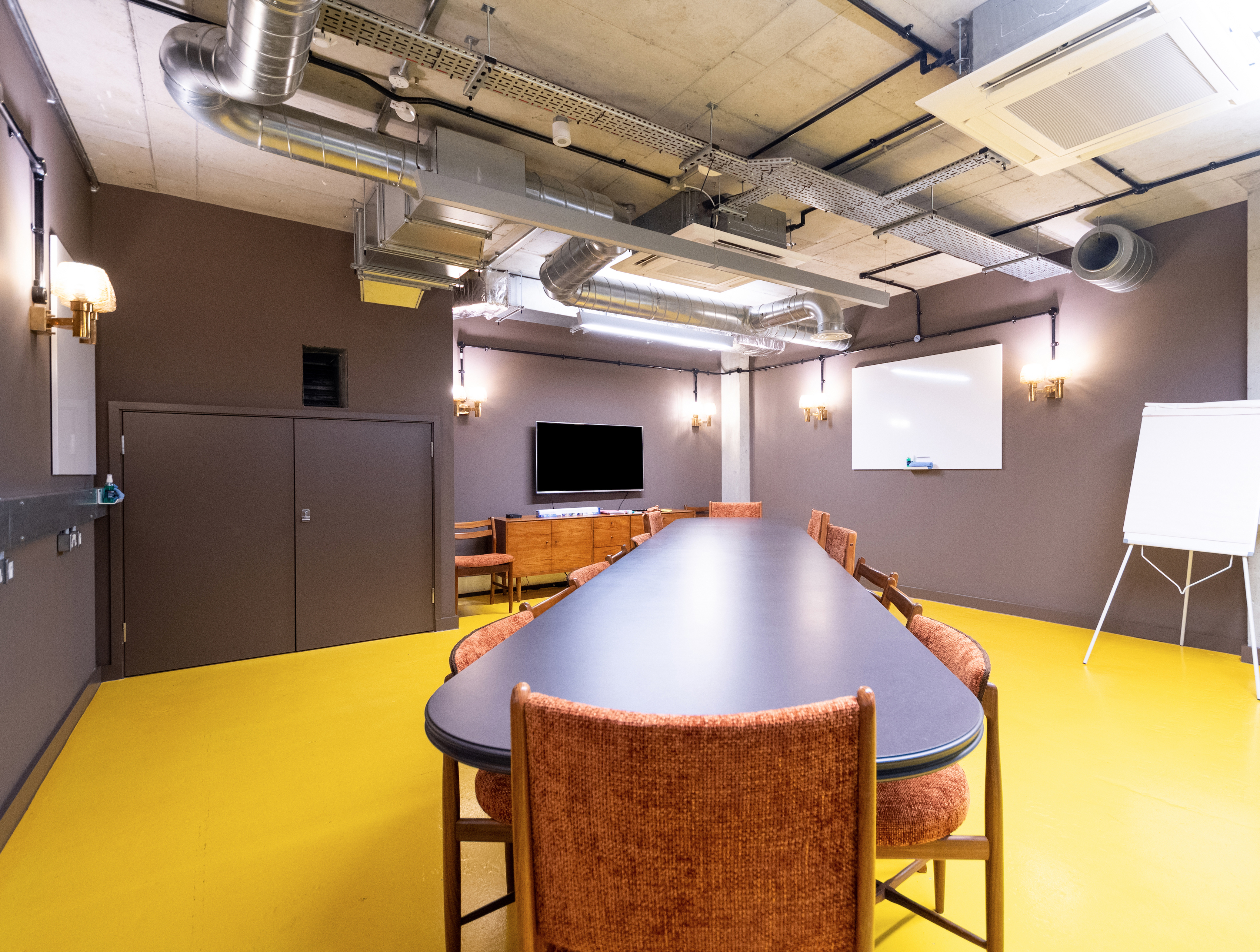 Modern meeting room with long table, ideal for collaboration and presentations.