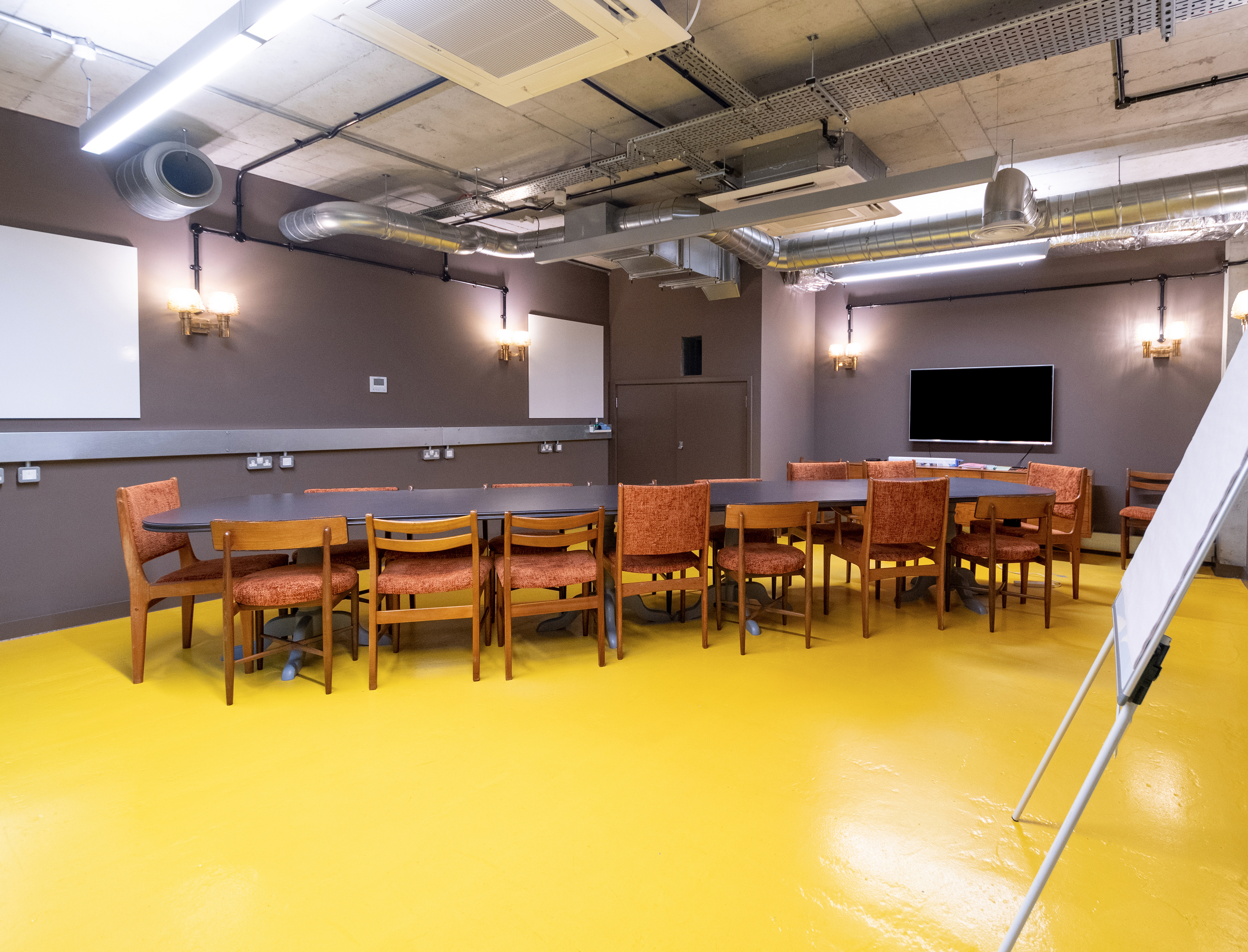 Collaboration Space in The Fisheries with bright yellow flooring for workshops and meetings.