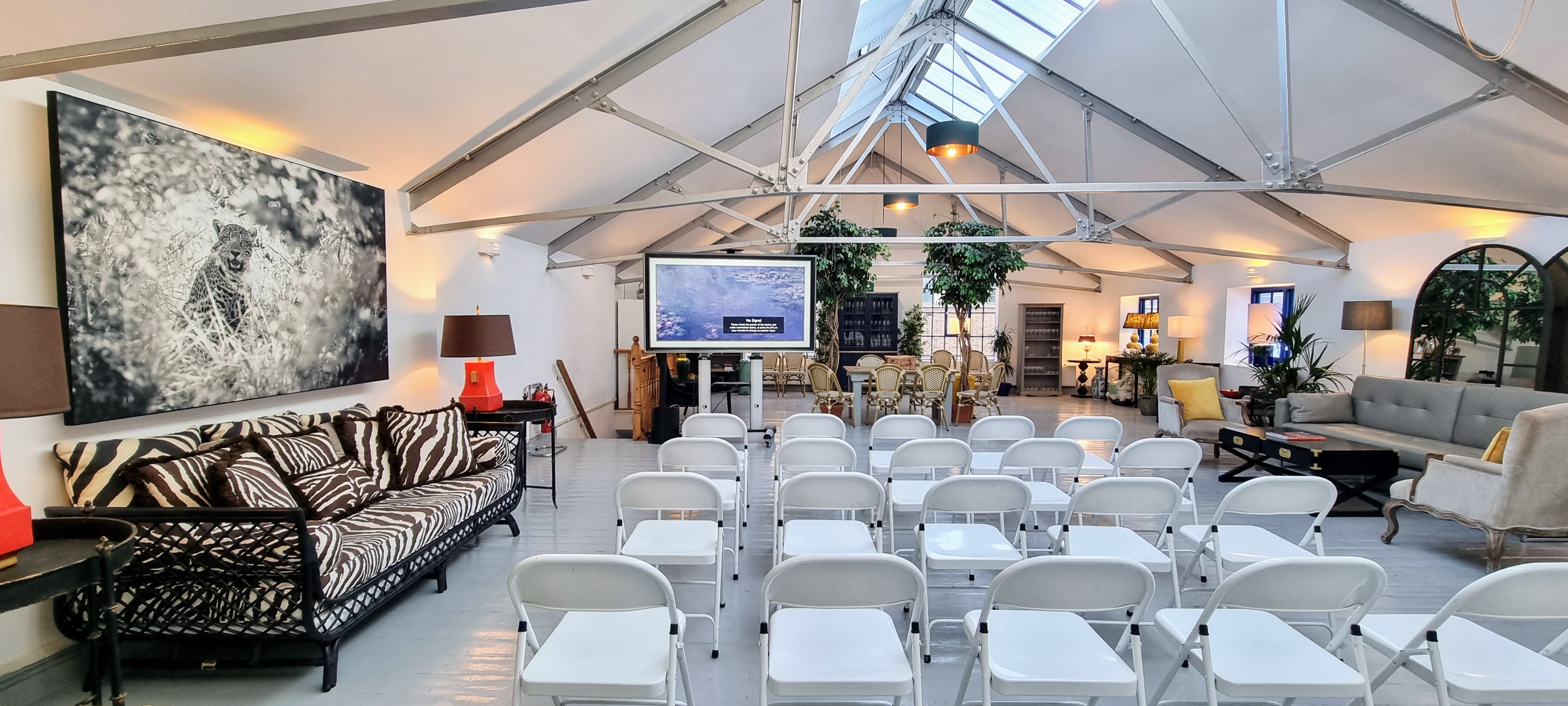 L'Atelier event space in London with white chairs for presentations and networking.