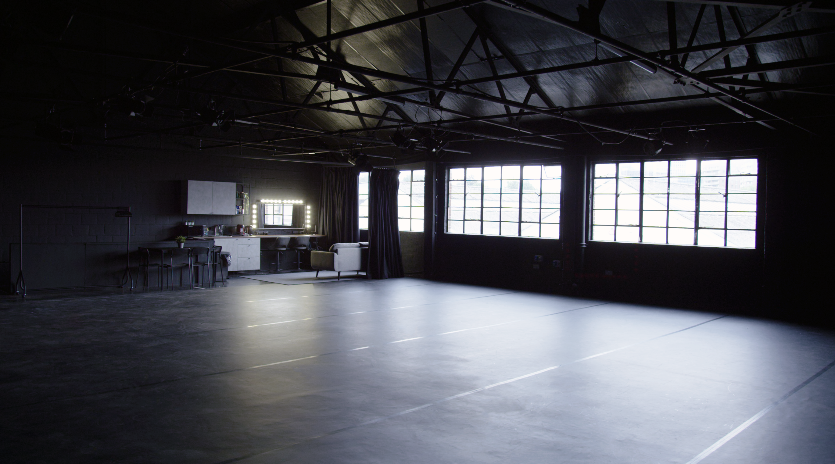 Versatile industrial event space with large windows for workshops and gatherings.