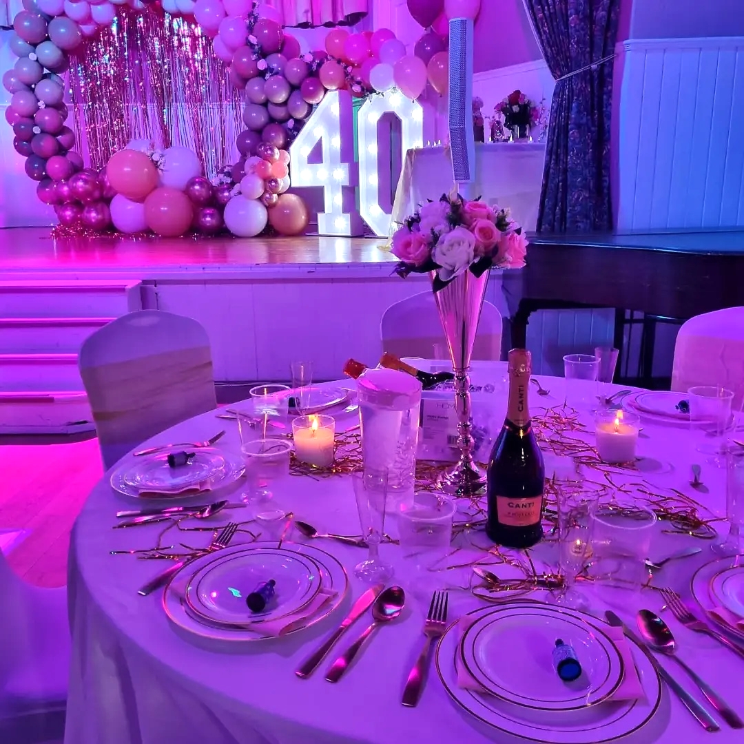 Elegant event space with fine china and festive balloons for celebrations.