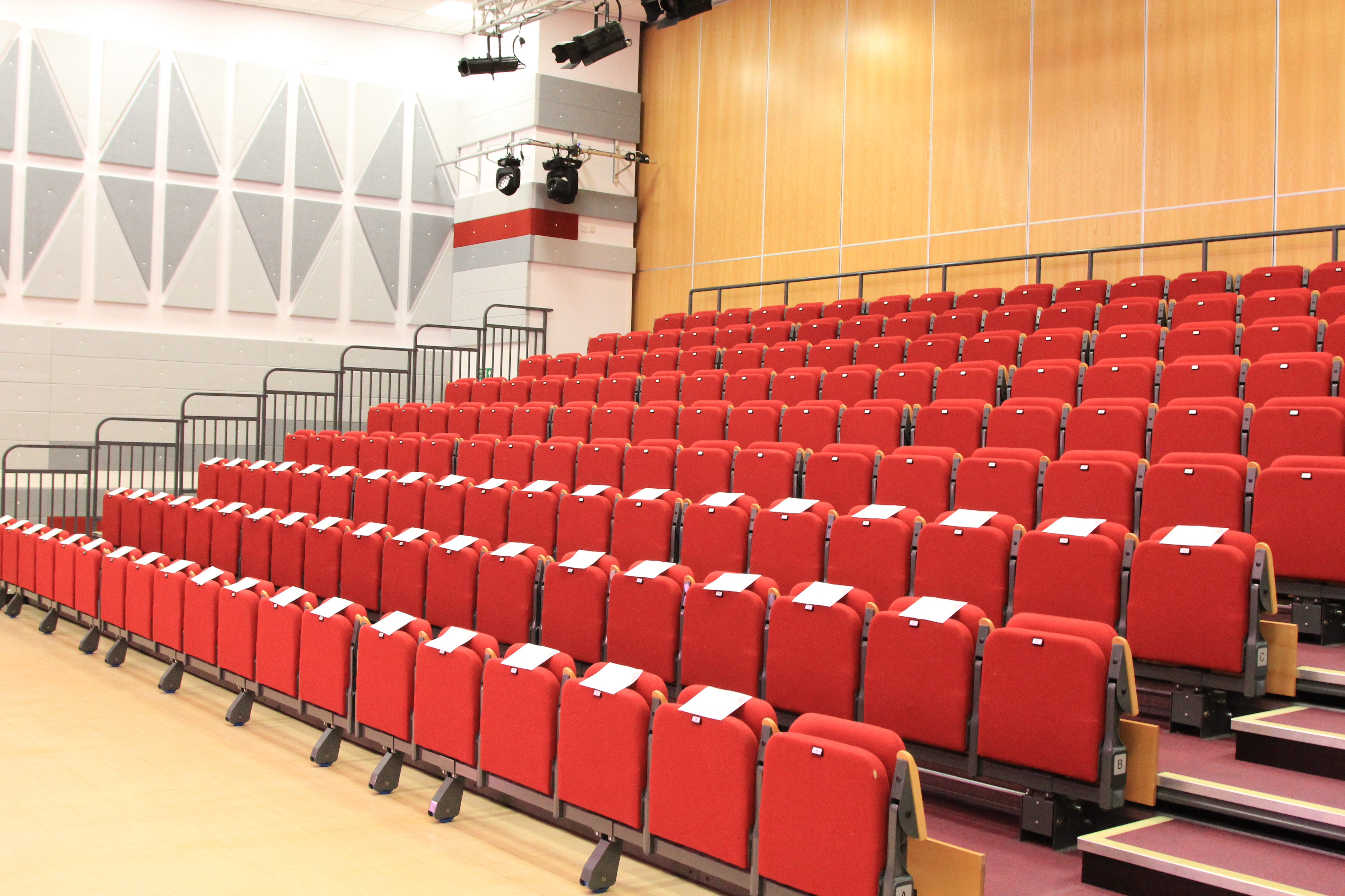 Lecture theatre with red tiered seating, ideal for STEM presentations and events.