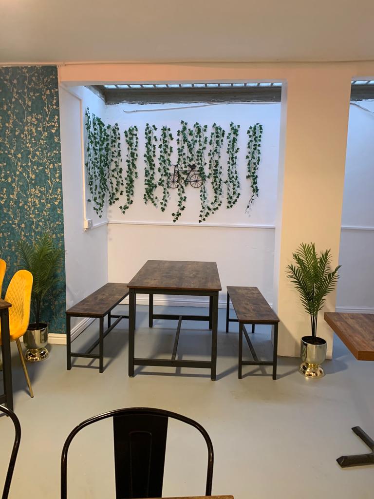 India Room at Biryani Pot: rustic table, greenery; perfect for meetings and gatherings.