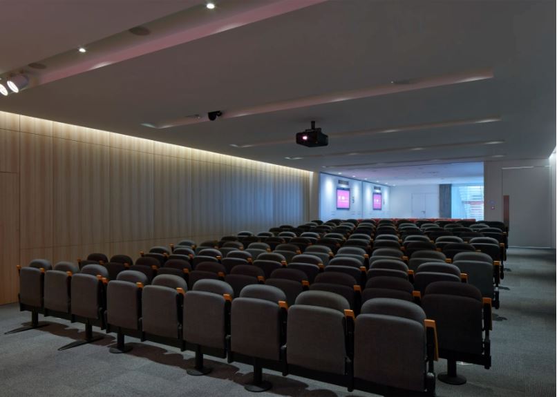 Modern conference room with tiered seating for corporate meetings and seminars.