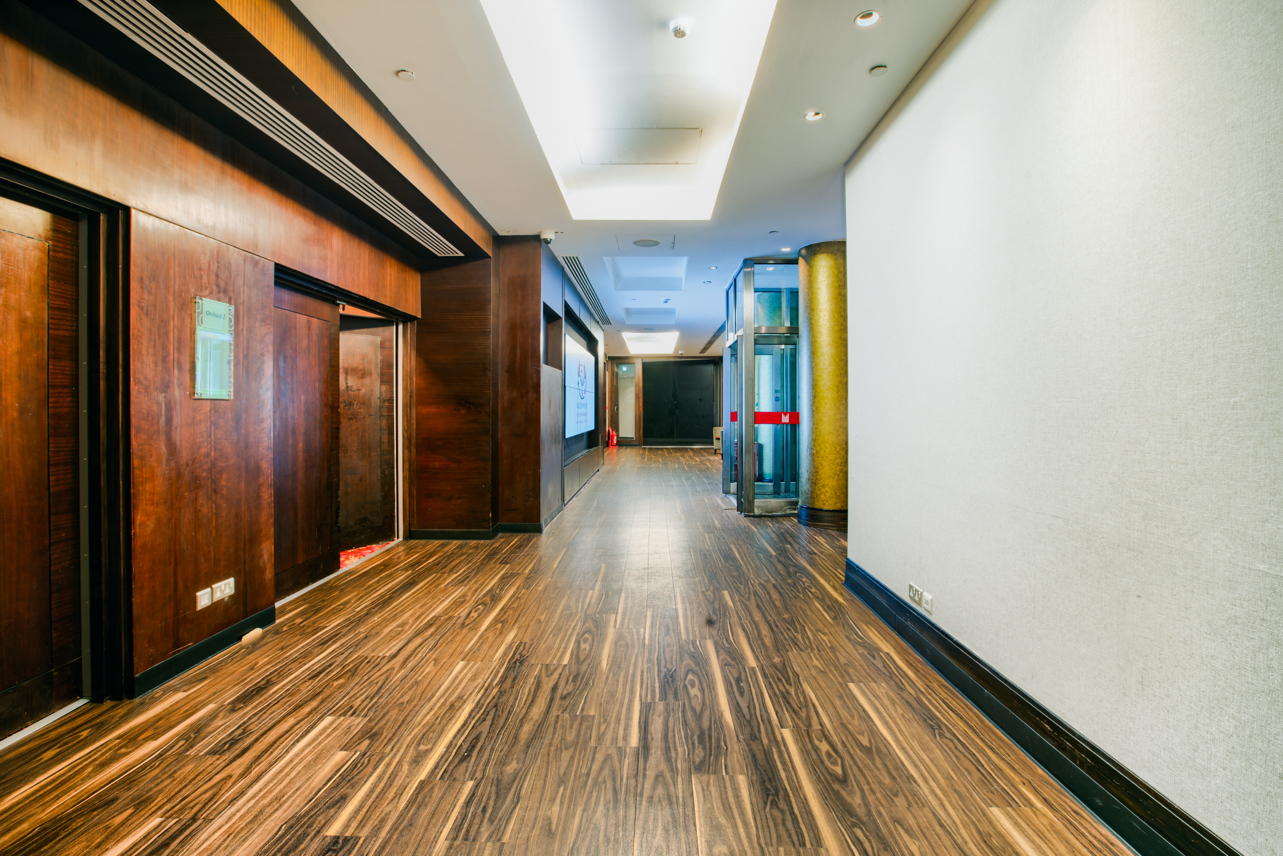 Kingdom Suite corridor at Millennium Gloucester, warm wood finishes for events and networking.