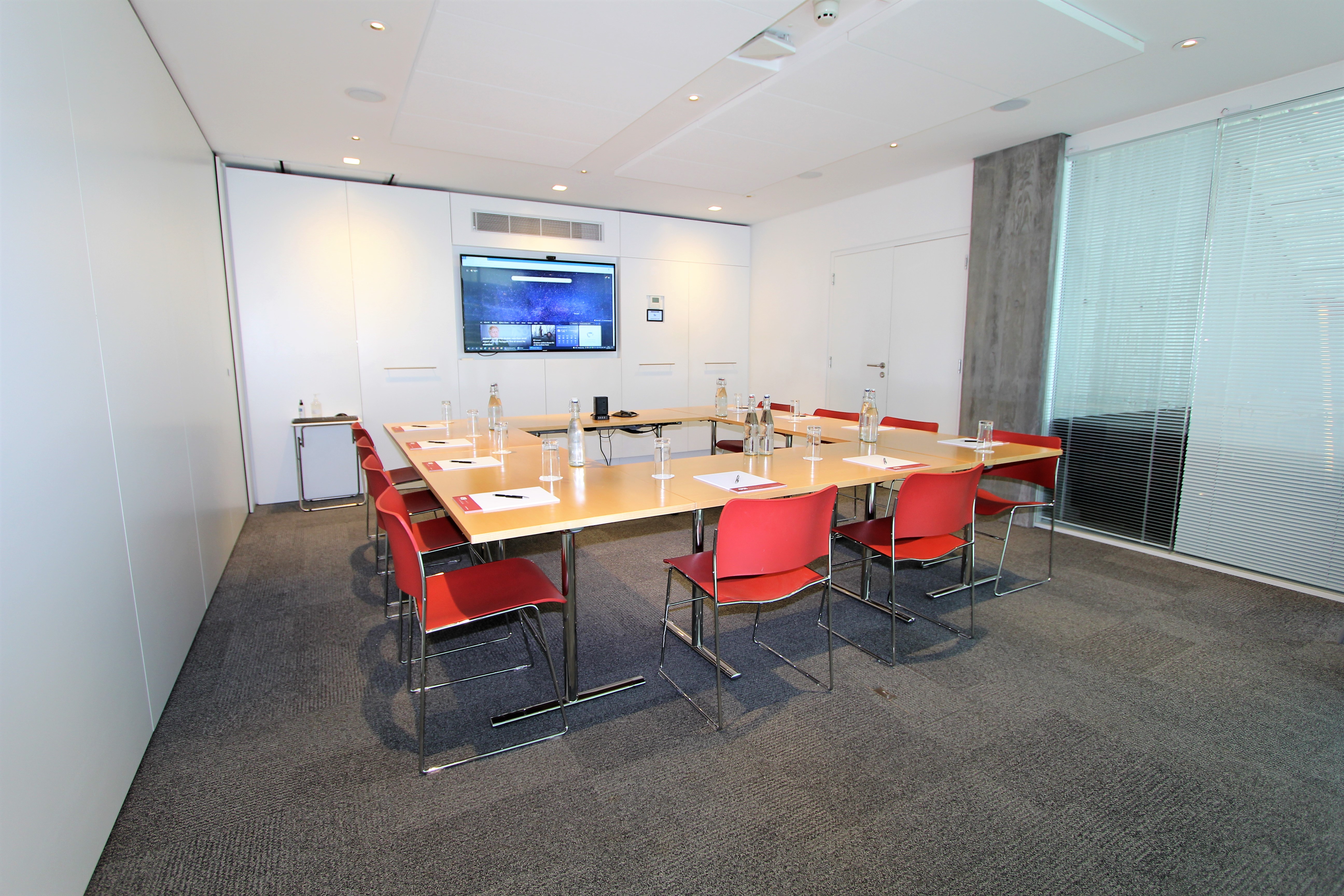 Modern meeting room with long table, ergonomic chairs for collaboration and presentations.