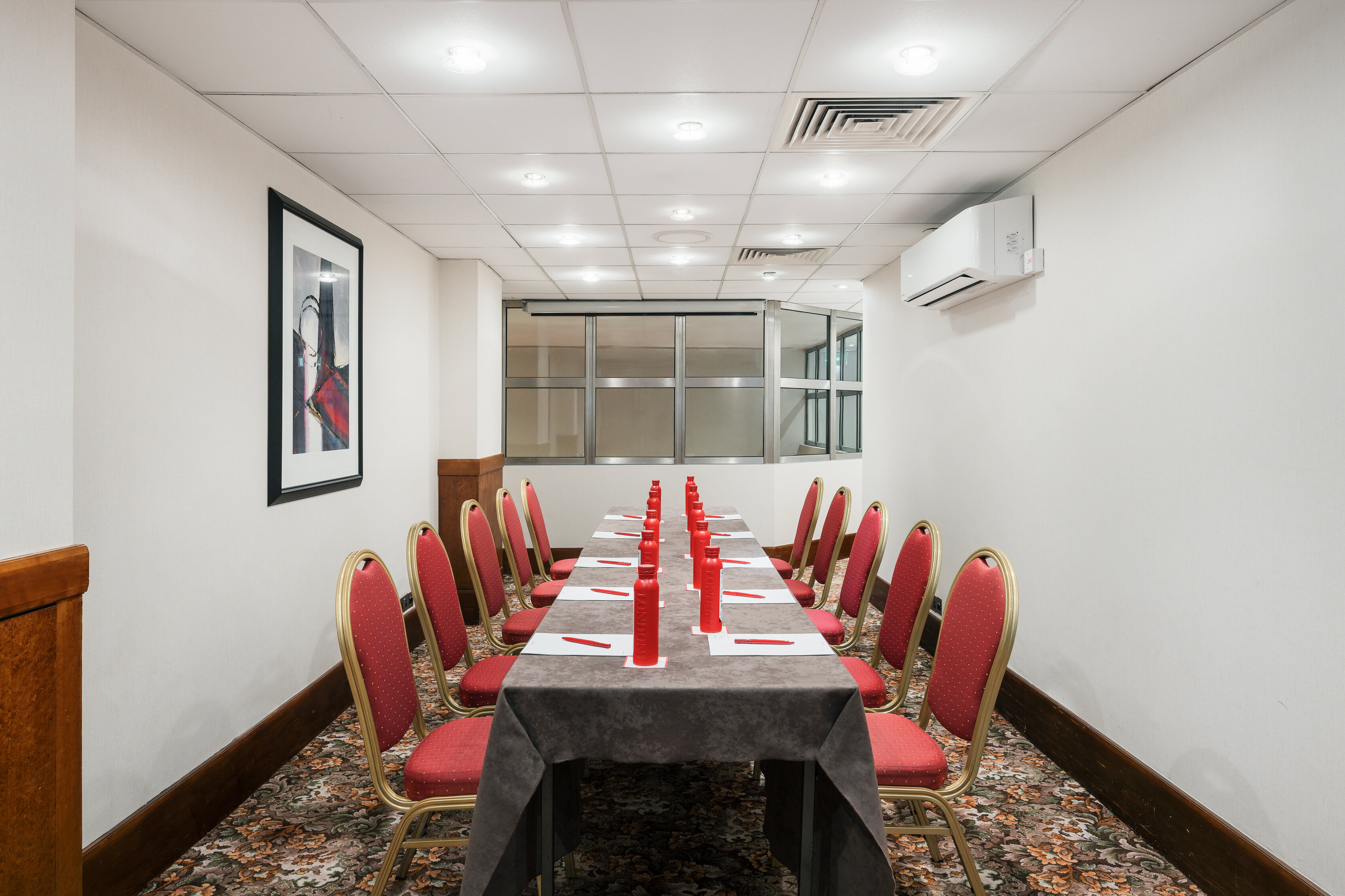 Prince Boardroom in London, elegant dining setup with red accents for formal events.