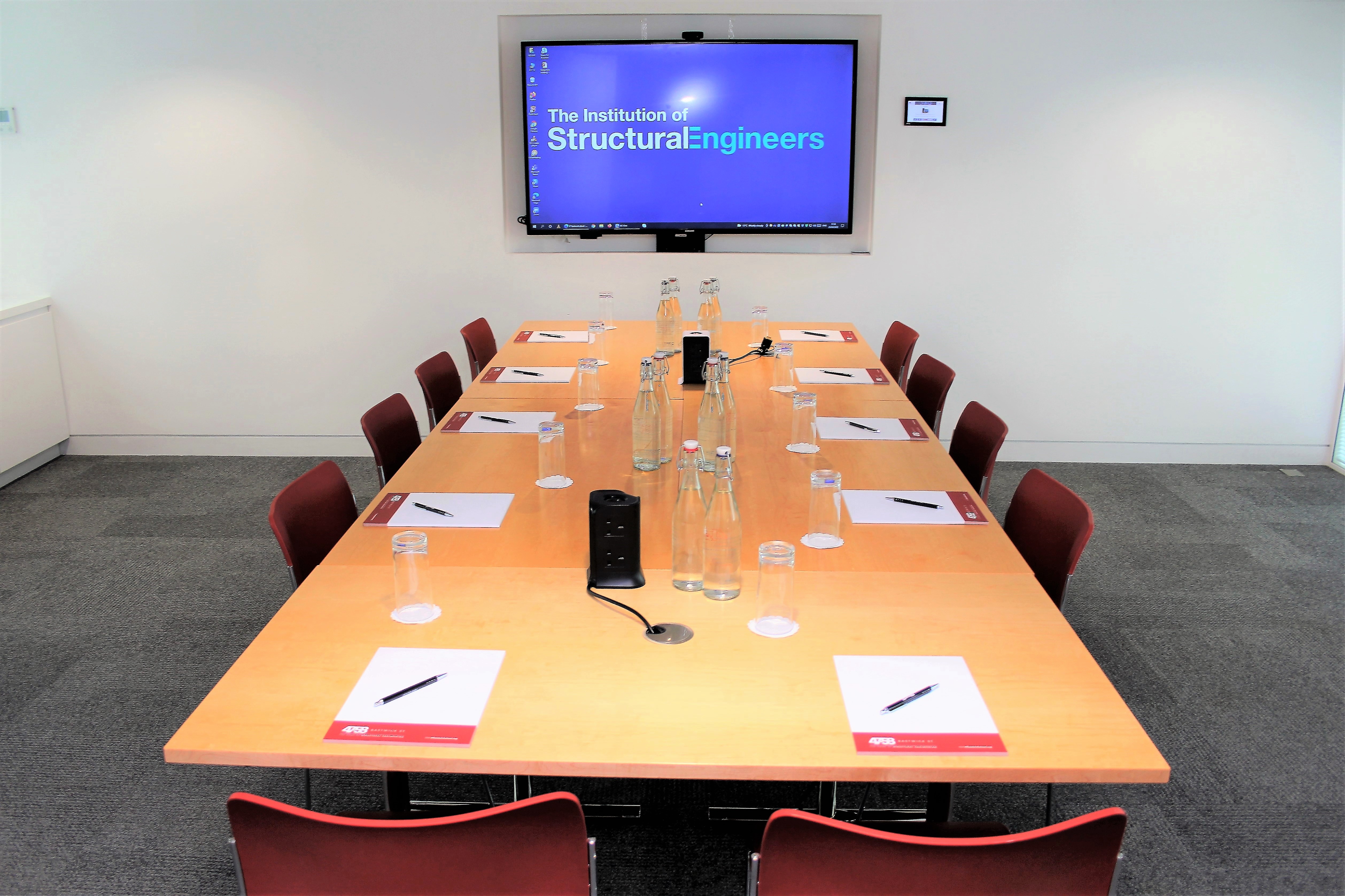 Meeting room at Bastwick 2, featuring a long table and branding screen for professional events.