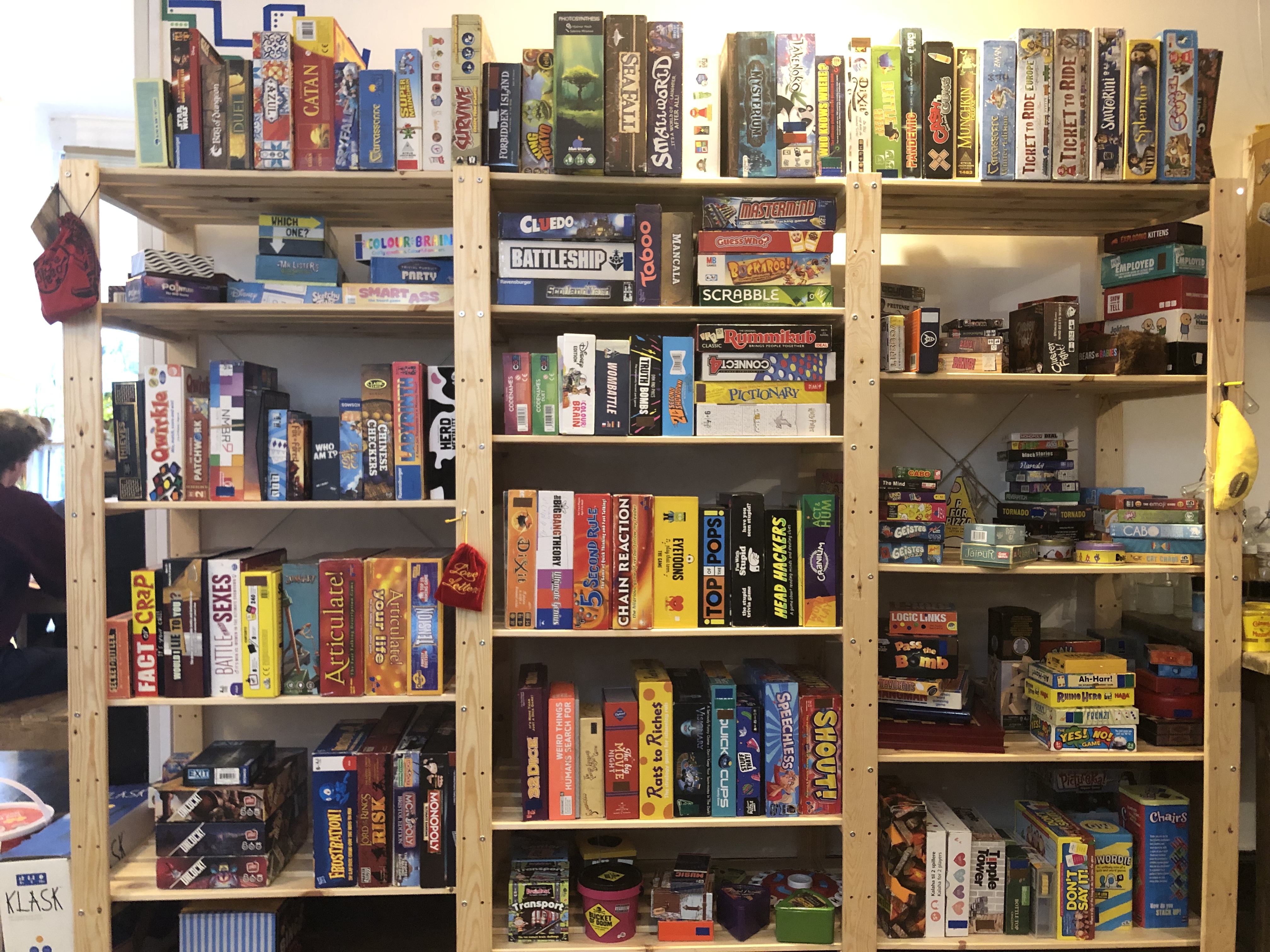 Diverse board games shelf at Replay Bristol for team-building and networking events.