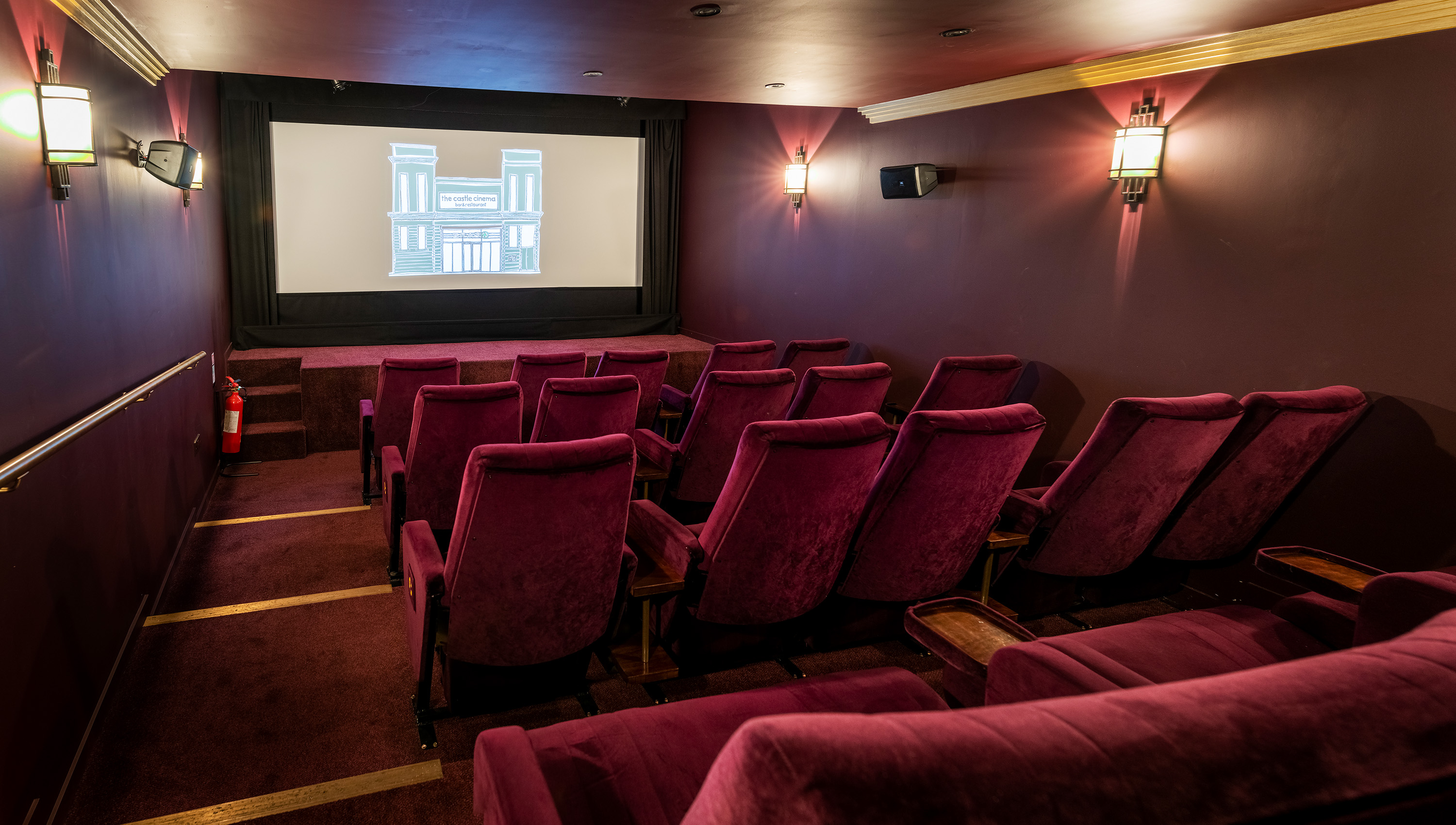 Cozy screening room with burgundy seating for private events and film viewings.