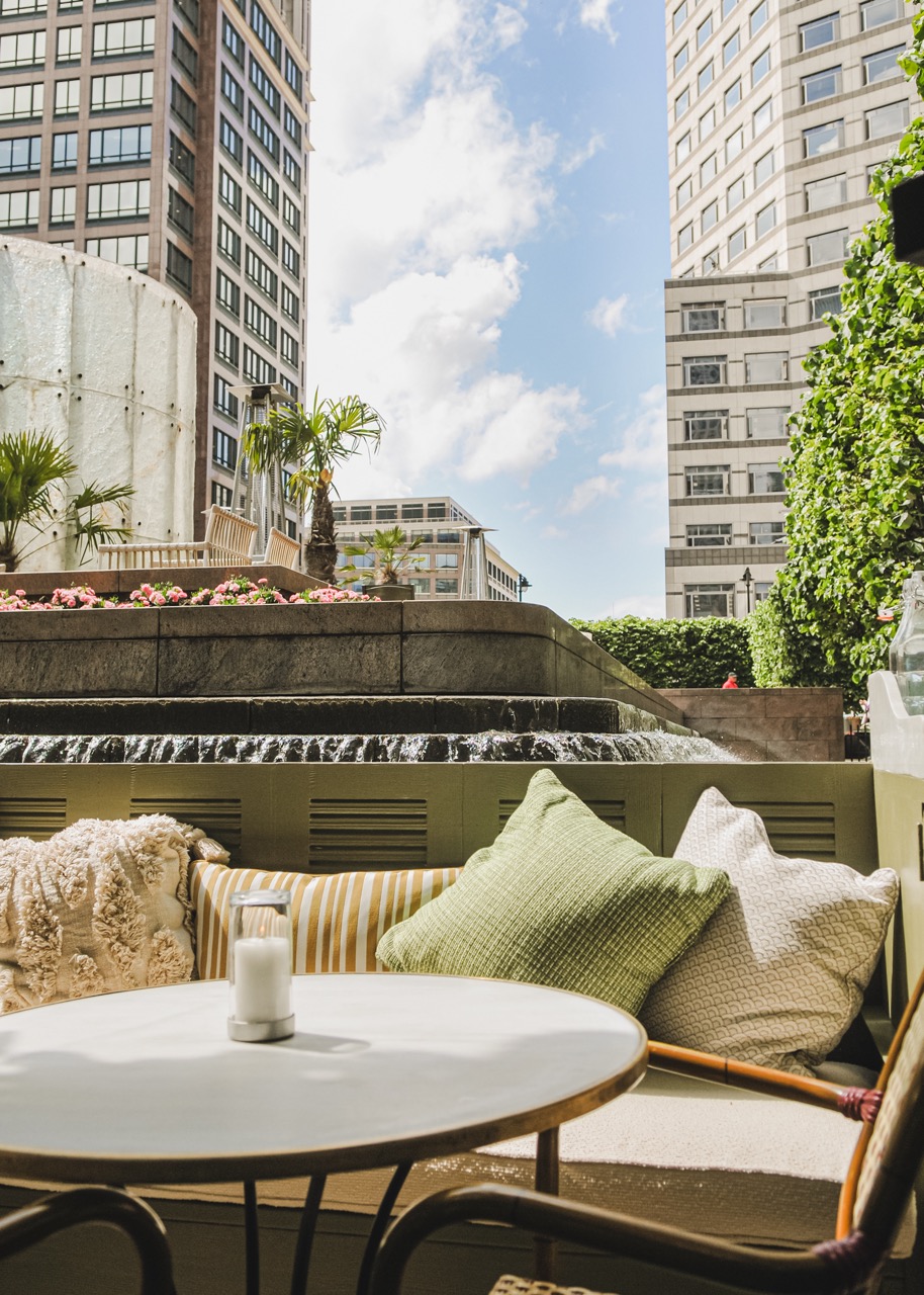 Serene outdoor event space at La Terrazza with lush greenery and water feature.