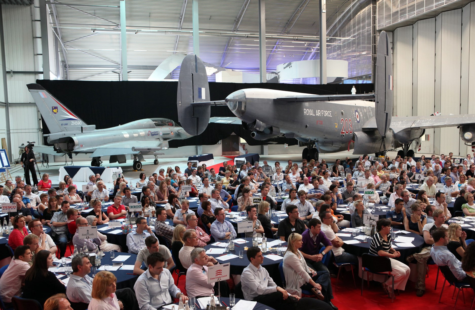 Conservation Hall at IWM Duxford with audience engaged in a presentation event.