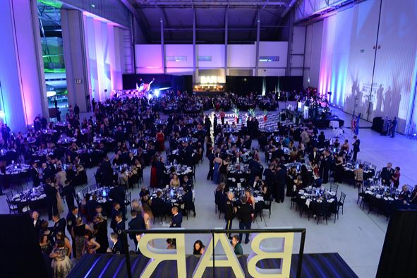 "Conservation Hall event with elegant tables and vibrant atmosphere at IWM Duxford."
