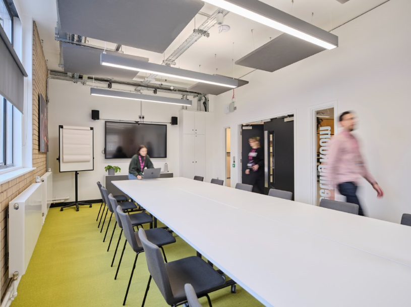 Modern meeting room with long table, ideal for collaborative events and presentations.