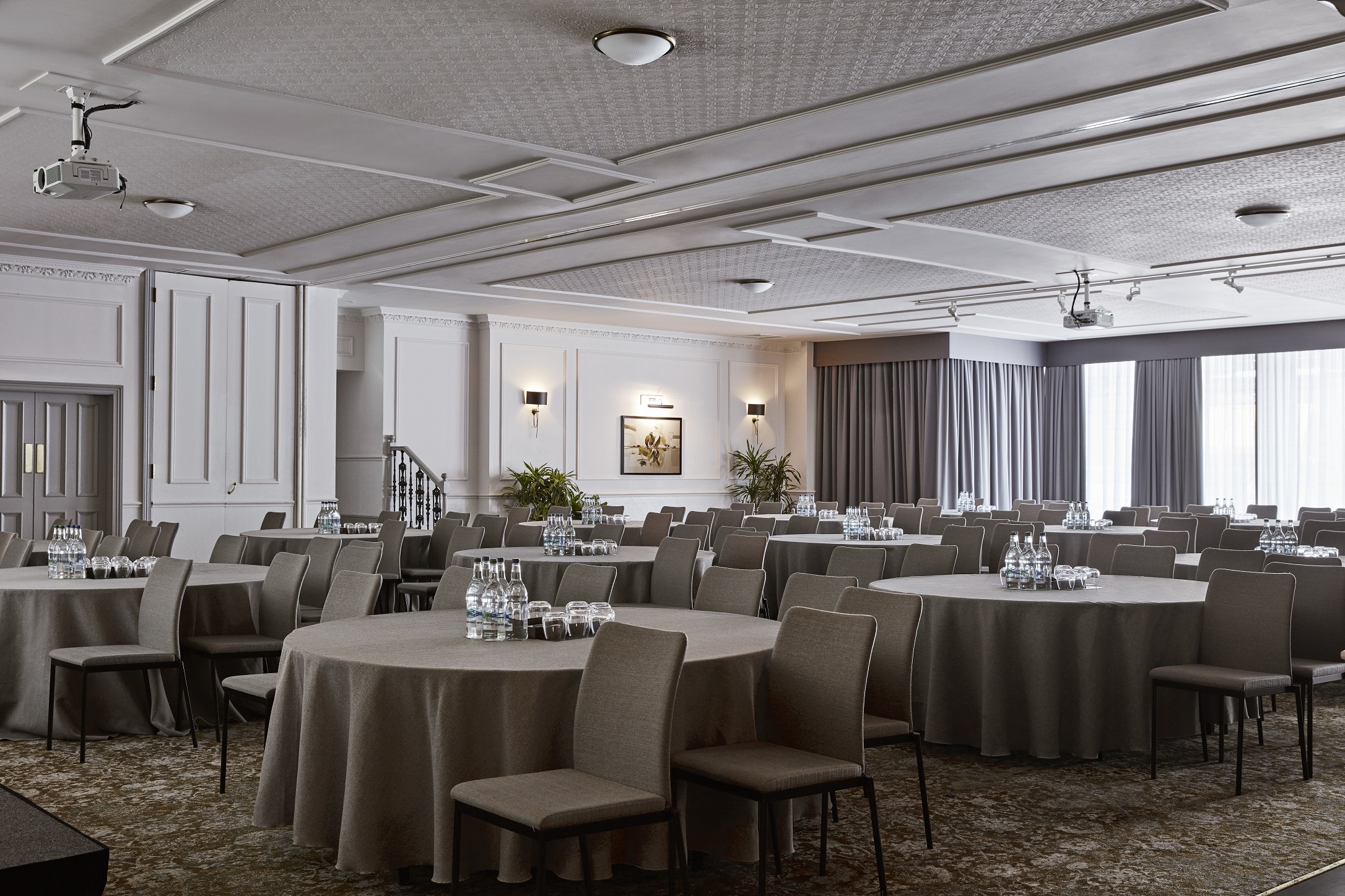 Versatile meeting room with round tables, ideal for workshops and conferences.