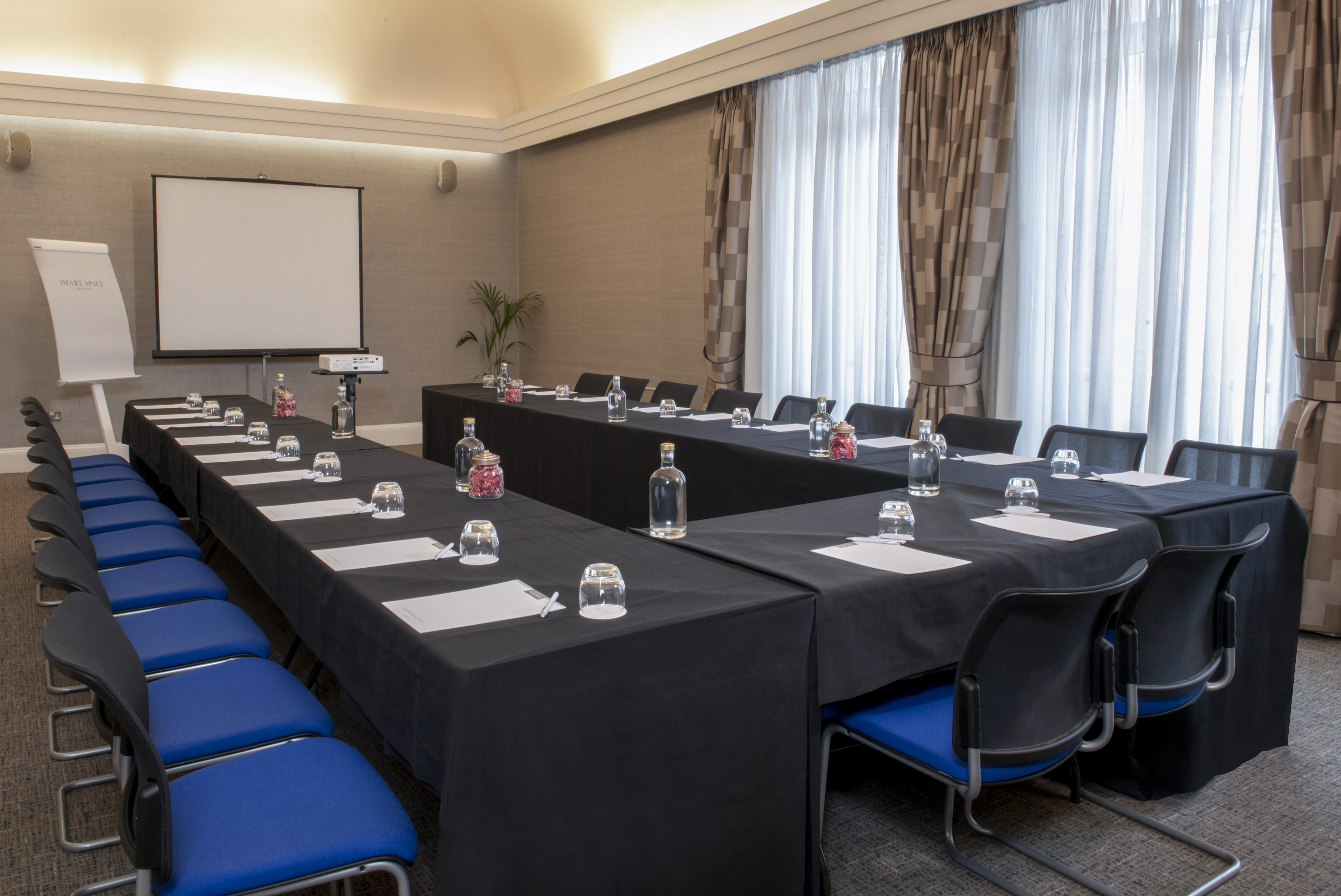 Oxford Suite meeting room with black tables and blue chairs, perfect for professional events.