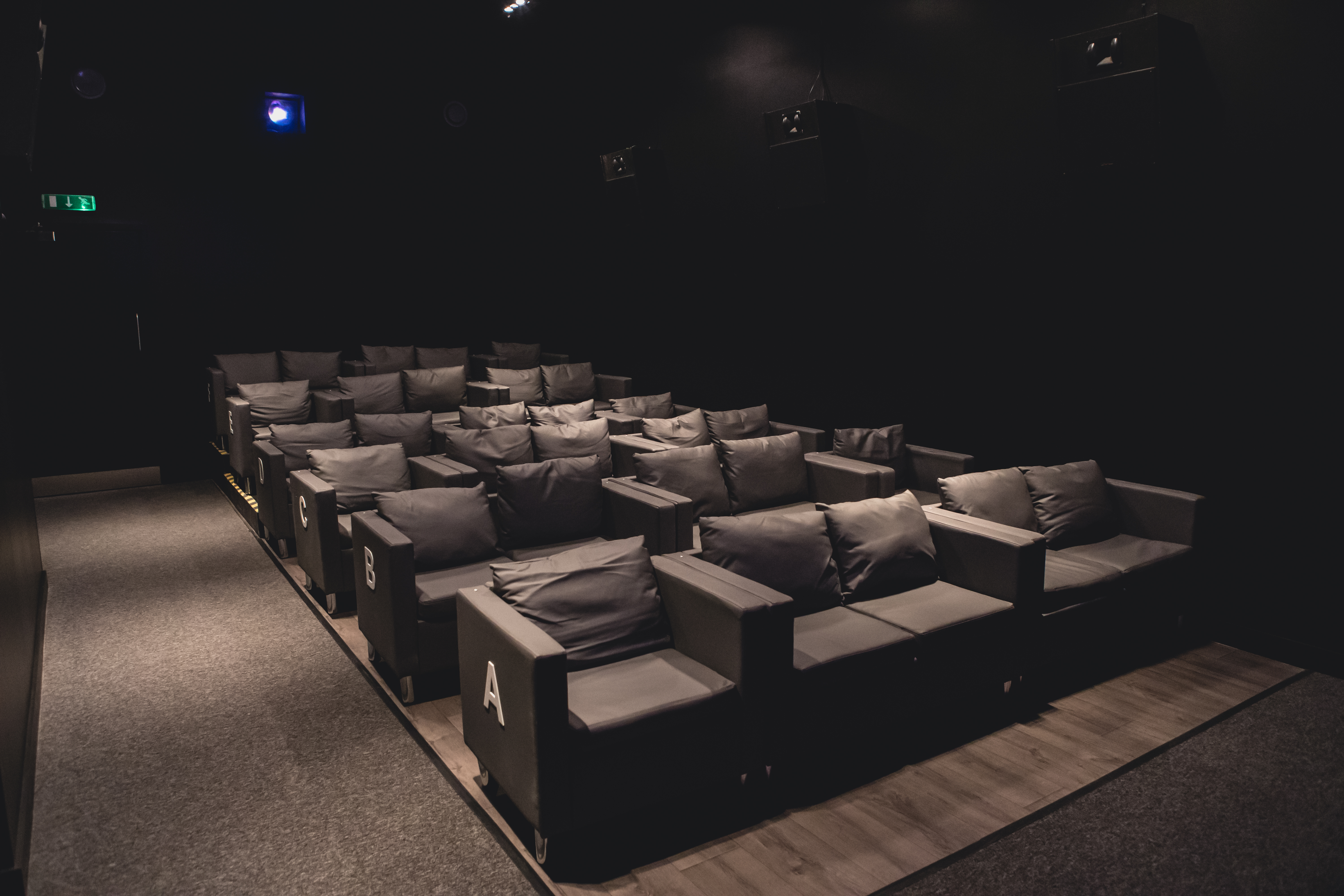 Intimate cinema seating with plush couches for film screenings and presentations.