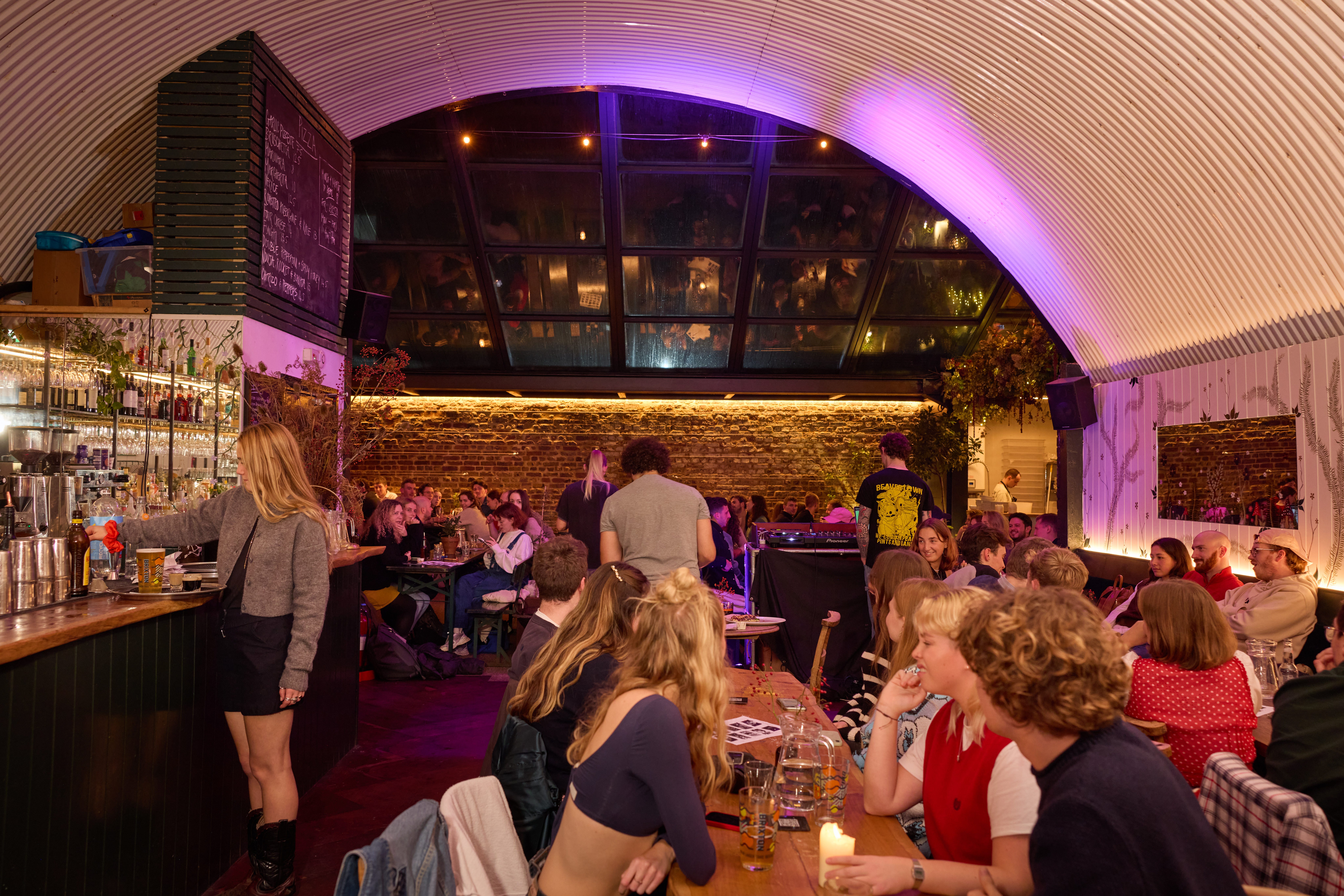 Vibrant bar area with glass ceiling, perfect for networking events and social gatherings.