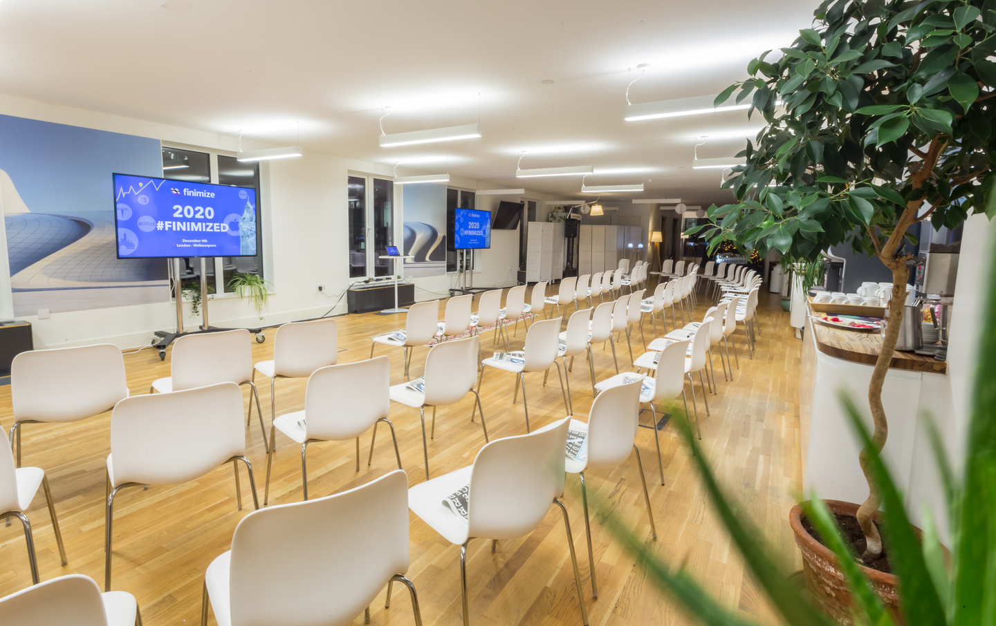Rooftop Kitchen event space with white chairs, ideal for presentations and networking.