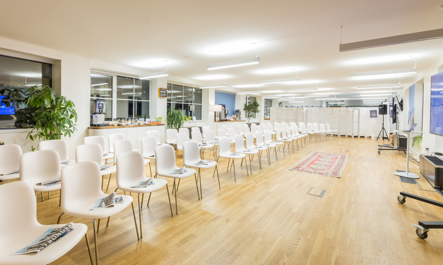 Rooftop Kitchen event space with white chairs, ideal for meetings and presentations.