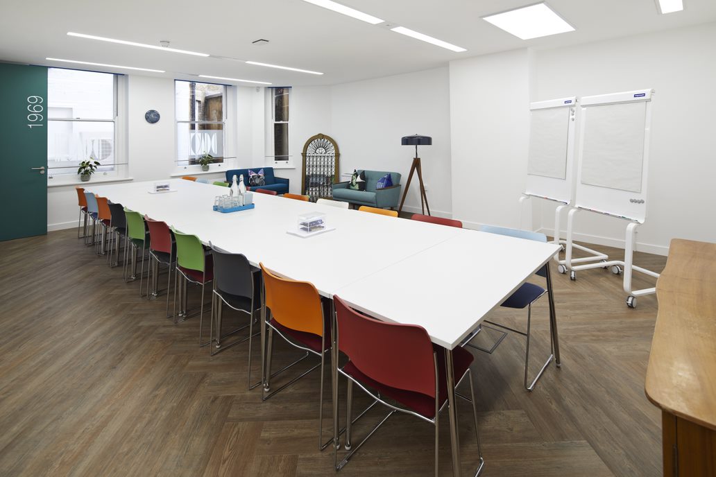 Modern meeting room with colorful chairs, ideal for workshops and brainstorming sessions.