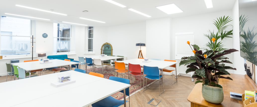 Modern meeting space with colorful chairs, ideal for workshops and brainstorming sessions.