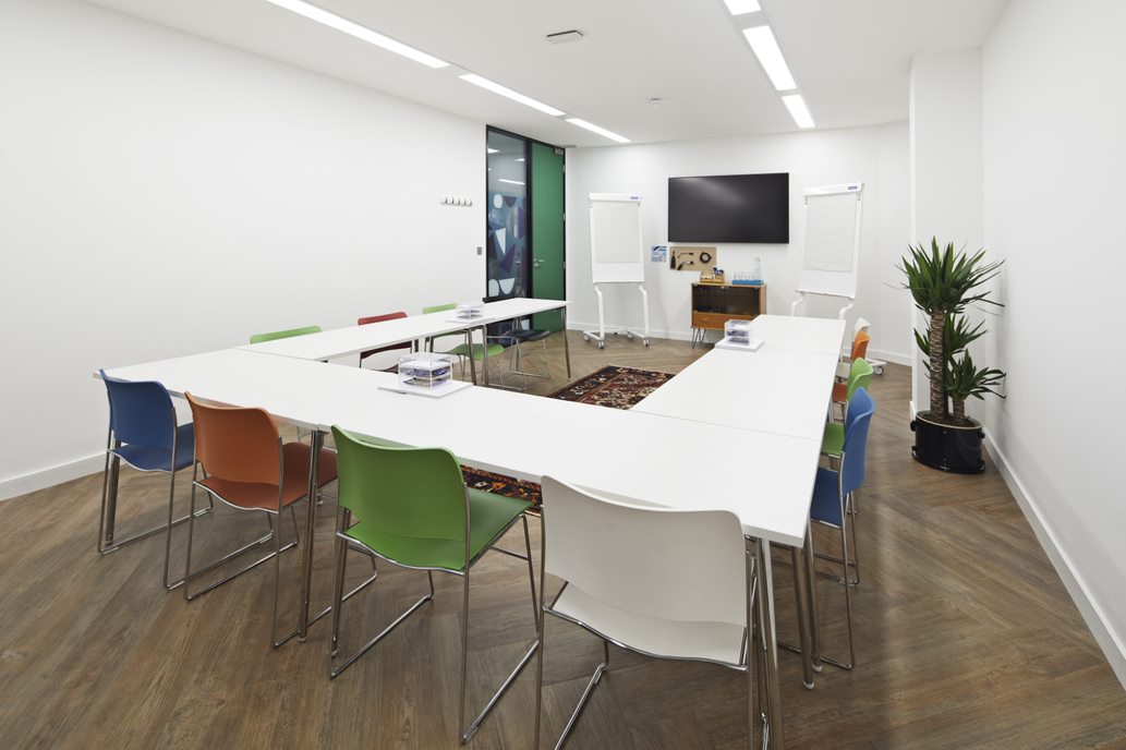 Modern meeting room with U-shaped table, ideal for presentations and brainstorming.