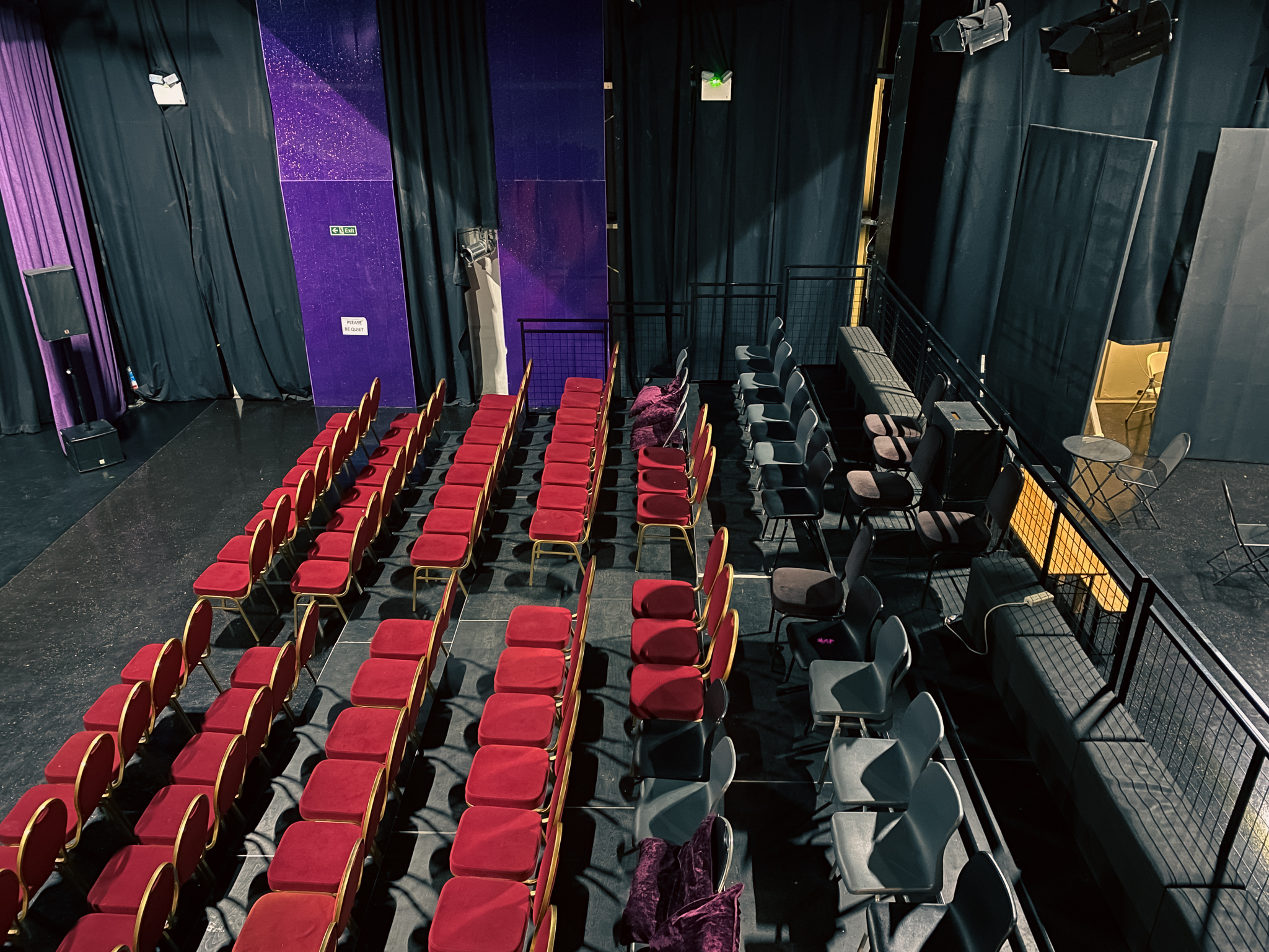 Versatile event space with red and gray seating, ideal for presentations and workshops.